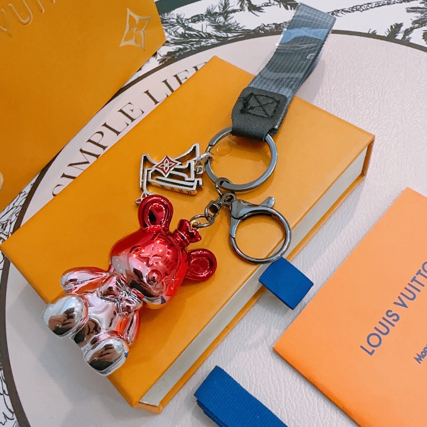 Louis Vuitton Anger Forest Bear Charm Keychain pendant Gunmetal gray metal metallic red and rose gold bear charm gray woven strap silver-tone logo charm with red enamel accents 12cm total strap length