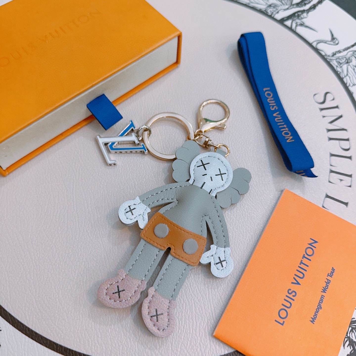 Louis Vuitton Anger Forest KAWS Companion Key Charm pendant Gold-tone metal silver-tone metal blue enamel gray leather white leather tan leather pink leather black stitching 12cm total charm length