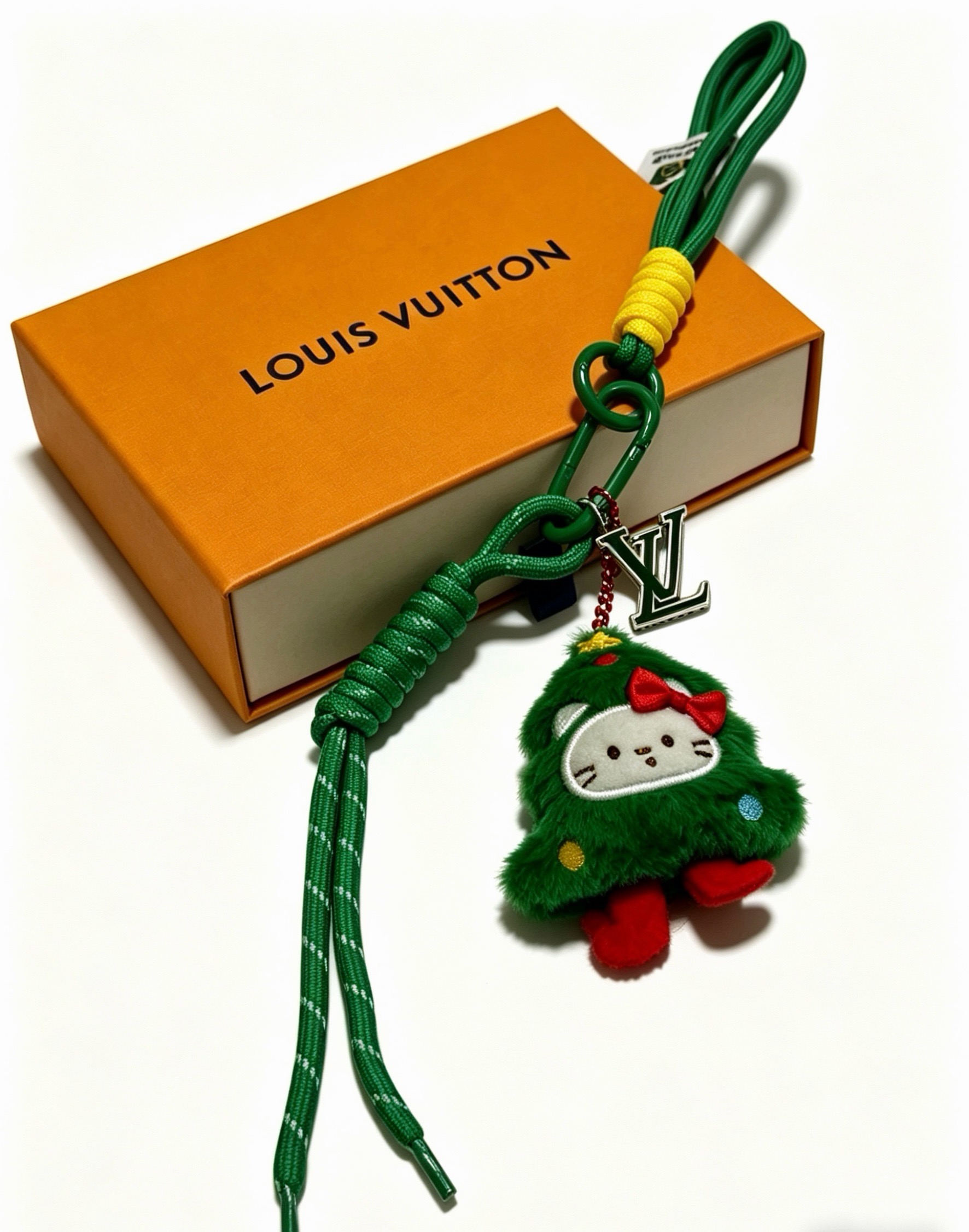 Louis Vuitton Anger Forest Christmas Tree Hello Kitty Charm Keychain pendant Green cord with yellow wrap silver-tone LV logo charm green plush charm with red bow feet white face yellow and blue accent dots 20cm total strap length