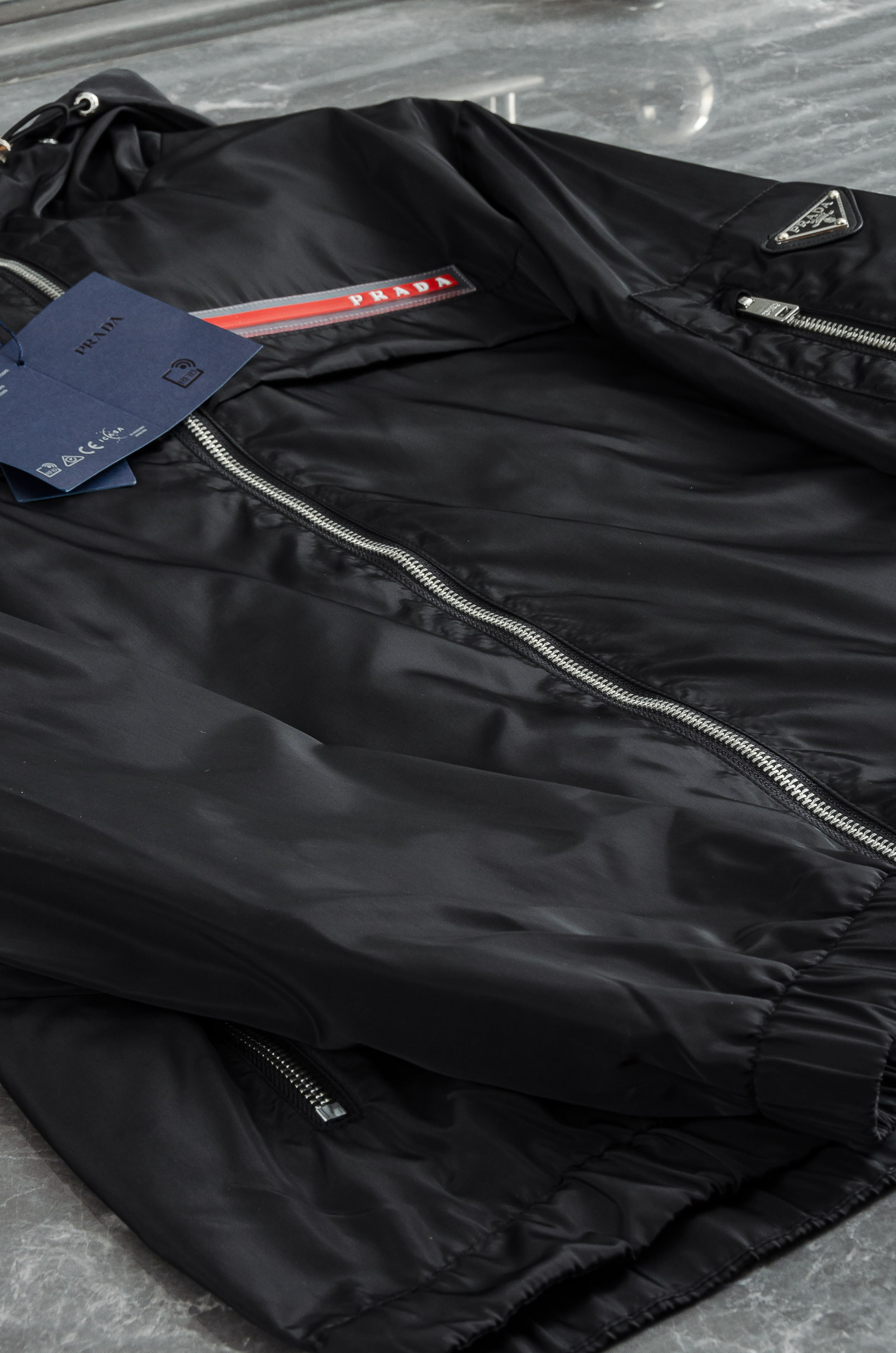 Pra*da 普拉达真标防伪芯片系列#连帽防水夹克外套，同步官网发售！原厂代工出品，该款夹克外层超柔聚酯