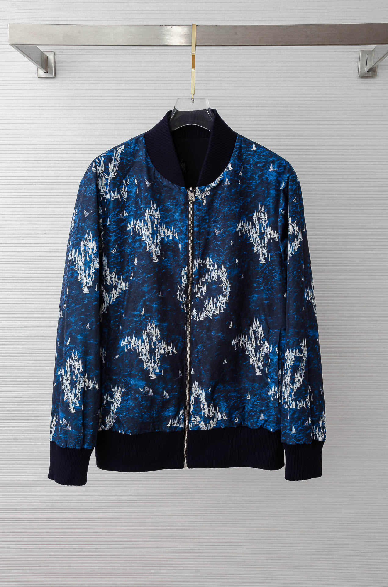 NO:518189,2 Donkey brand LV [Double-sided wear] MONOGRAM printed windproof. This windproof is made of lightweight technology fabric, which depicts the scene of the pocket fleet sailing on the blue water with Monogram Regatta pattern. Marque 1Vuitton Déposée rubber patches embellish the chest, and the adjustable hood is convenient for the collar. Crafts details and casual style: nylon, lined with polyester fiber, full-frame logo printing, adjustable hood, and can be folded into the collar, breathable holes, elastic cuffs and hem, hidden zipper front closure, side pockets, rubber patches embellished on the chest  The printing process pattern is a combination of sailboats and waves, presenting a delicate and layered visual effect. It adopts high-precision digital inkjet printing, and the pattern is printed directly on the fabric through inkjet, supporting high-resolution complex patterns; the pattern penetrates the fiber inside, and has better wear resistance than surface printing. The inside of the fabric may be composited with microporous coating, which achieves windproof and breathable balance through hot pressing. The color reduction degree is high, and the design pattern can be accurately presented, making the white sailboat clear and vivid on the blue 'wave' fabric, and the printing is firm, so it is not easy to fall off due to washing, etc. The original fabric has a high number of tight woven structure to block cold air penetration, and the surface is attached with a water-spray coating, which has excellent tear resistance. The lining is suitable for pursuing light and quick-drying uses, but the balance between breathability and moisture absorption is required.  It has light and windproof characteristics, suitable for outdoor or casual style, with a certain luster on the surface, improving texture and fashion. At the same time, this fabric is easy to handle and has good wrinkle resistance.,,louis vuitton,louis vuitton,hats,alexander wang198609092 驴牌LV【双面穿】 MONOGRAM 印花防风 . 本款防风取材轻盈科技面料,以 Monogram Regatta 图案描摹袖珍船队于蔚蓝水面扬帆起航的情景.Marque 1Vuitton Déposée 橡胶贴饰点缀胸前,可调节风帽方便收入衣领. 工艺细节休闲版型 锦纶,内衬聚酯纤维,全幅标识印花 ,可调节风帽,折叠后可收入衣领 ,透气孔眼,弹力袖口和下摆,隐藏式拉链前襟 侧袋 胸前点缀橡胶贴饰 印花工艺图案是帆船与海浪组合,呈现出细腻且有层次感的视觉效果,采用高精度数码喷墨印花,通过喷墨方式将图案直接打印在面料上,支持高分辨率复杂图案；图案渗透纤维内部,耐磨性优于表面印刷.面料内侧可能复合微孔涂层,通过热压工艺实现防风透气平衡. 色彩还原度高,能精准呈现设计图案,让白色帆船在蓝色“海浪”面料上清晰、生动,且印花牢固度好,不易因洗涤等脱落 . 原版面料高支数紧密编织结构阻挡冷风渗透,表面附加防泼水涂层,抗撕裂性优异.内衬适合追求轻便、快干的用途,但需权衡透气与吸湿的平衡 具备轻薄、防风特性,适合做户外或休闲风格,表面有一定光泽感,提升质感与时尚度,同时这种面料便于打理,抗皱性较好 .,,louis vuitton,louis vuitton,hats,alexander wang,Men's clothing