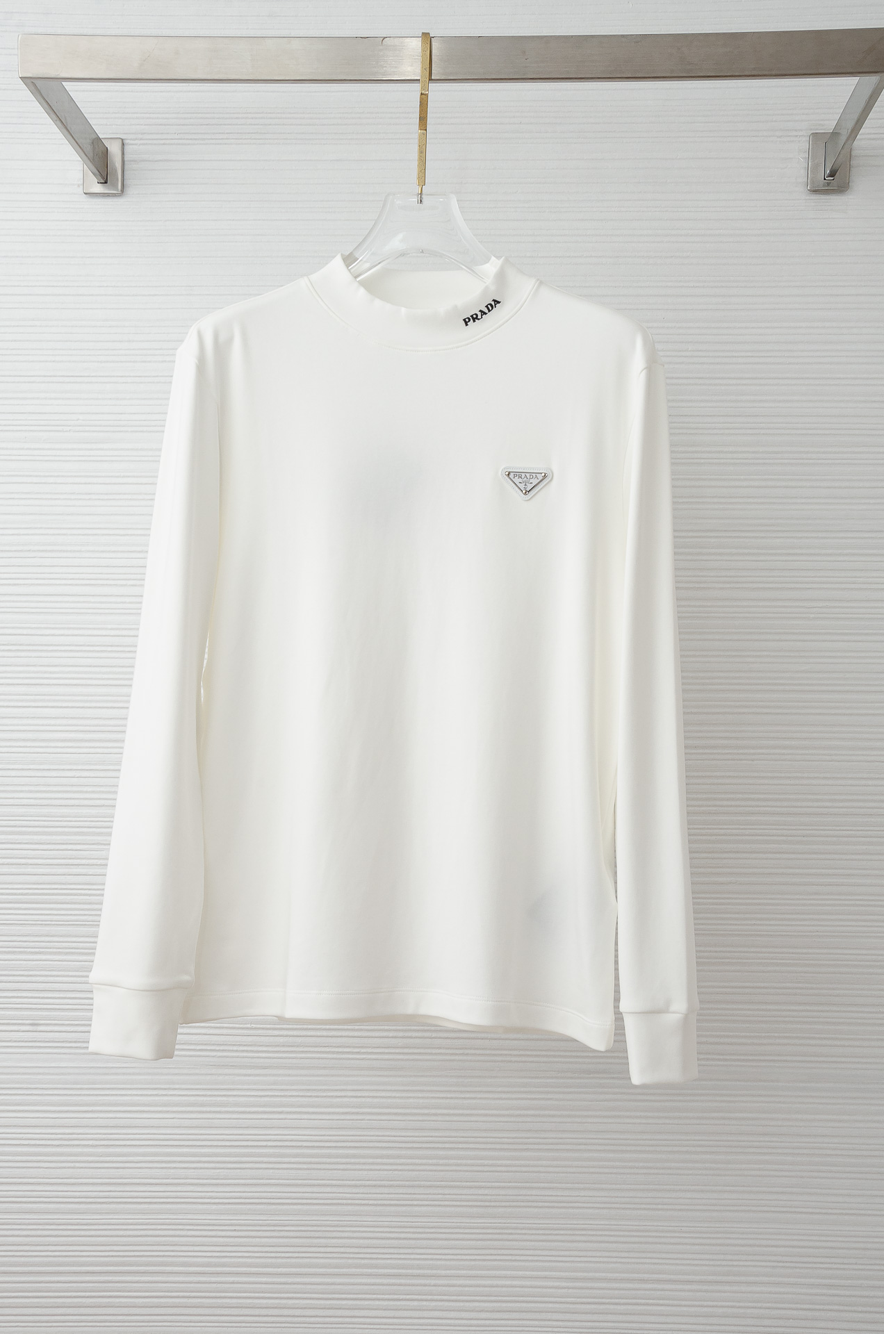 NO:606783,prada 25FW new autumn and winter three-dimensional embroidered men's long-sleeved T-shirt# puts the focus on the fabric. For overseas orders, the customer supplies imported 42 cotton 58 polyester fabrics and is woven with high-end ingredients. The fabric is heavy and extremely high-density. The fine grid texture is clearly visible on the surface, which is enough to highlight its high-end texture. It is wear-resistant and anti-wrinkle and has good drape. It perfectly supports the shape of the entire shirt!  Breathability and convenience are of course not to mention, and it also has a certain degree of wrinkle resistance and stain resistance, which greatly reduces the convenience of daily care and storage. The soft, gentle but crisp gold fabric, and after the texture combination of the fabric itself, will slightly show different colors and textures under different lights.  The feel allows you to be versatile and easily adapt to various occasions. The whole dress is simple and clean, with a fit and crisp fit, and an excellent wearing effect. And the inside is designed with velvet, which has a delicate touch and warm care for you in autumn and winter. It is warm and wind-resistant. Whether worn alone or layered, it is a very versatile and practical style!  The classic straight version has a good effect on the upper body, and is classic and versatile. The classic embroidery details on the chest are embellished. I believe that you who have taste will be familiar with it!  Every detail is made with exquisite care and is a test of craftsmanship. Whether it is fabric cutting or craftsmanship, it fully embodies the brand's century-old history and skilled garment production technology. It is perfect in every aspect, with no flaws. The style is fashionable and versatile, and it can be used between leisure and business with ease. It is a must-have for quality control people.  Color black/white Size M-3XL (48-56), prada, shirts, tees, t-shirt, gold, alexander wang19860909prada 25FW秋冬新款 立体刺绣男士长袖T恤衫#把重心都放在了面料上,出口海外的订单,客供进口精选42棉58聚酯纤维面料高端成分织造而成,面料克重足且密度极高,表面清晰可见的细格肌理,足以凸显出它的高级质感,耐磨抗皱垂感佳,将整件衬衫版型承托的极其完美！透气性跟便捷性自然不在话下,还具有一定的抗皱性与耐脏度,大大减少了日常中的打理与保存便捷性.柔软温和却挺括的黄金面料,并且经过面料本身的纹理组合之后,在不同光线下会轻微显现出不一样的色泽跟质感,让你百变多样轻松应对各种场合.整件衣服都简洁干净,版型服帖挺括,穿着效果极佳.并且内里做了加绒的设计,细腻触感温暖呵护秋冬季节的您,保暖抗风,不管是单穿还是内搭都是非常百搭又实穿的款式！ 经典的直筒版型上身效果好,同时经典百搭,胸前经典刺绣细节点缀,相信有品味的你们一定不会陌生！每一处细节都做的非常的精湛考究,极其考验工艺技巧,无论是从面料裁剪还是工艺制作都完全体现了品牌百年的深厚历史以及娴熟的成衣制作工艺,不管是从哪一个方面看都完美到极致,毫无缺点,风格时尚百搭,休闲商务之间游刃有余,品控族必入的类型,可遇而不可求！ 颜色黑色/白色 尺码M-3XL（48-56）,,prada,shirts,tees，t-shirt,gold,alexander wang,Men's clothing