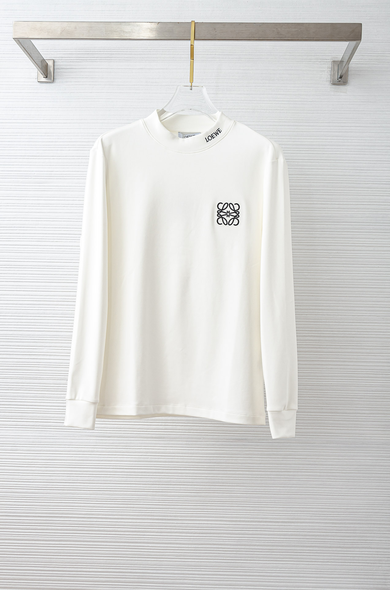 NO:606777,LOEWE's 25FW new autumn and winter three-dimensional embroidered men's long-sleeved T-shirt # focuses on the fabric. The fine grid texture clearly visible on the surface is enough to highlight its high-end texture. It is wear-resistant and wrinkle-resistant and has good drape. It supports the entire shirt shape perfectly!  Breathability and convenience are of course not to mention, and it also has a certain degree of wrinkle resistance and stain resistance, which greatly reduces the convenience of daily care and storage. The soft, gentle but crisp gold fabric, and after the texture combination of the fabric itself, will slightly show different colors and textures under different lights.  The feel allows you to be versatile and easily adapt to various occasions. The whole dress is simple and clean, with a fit and crisp fit, and an excellent wearing effect. And the inside is designed with velvet, which has a delicate touch and warm care for you in autumn and winter. It is warm and wind-resistant. Whether worn alone or layered, it is a very versatile and practical style!  The classic straight version has a good effect on the upper body, and is classic and versatile. The classic embroidery details on the chest are embellished. I believe that you who have taste will be familiar with it!  Every detail is made with exquisite care and is a test of craftsmanship. Whether it is fabric cutting or craftsmanship, it fully embodies the brand's century-old history and skilled garment production technology. It is perfect in every aspect, with no flaws. The style is fashionable and versatile, and it can be used between leisure and business with ease. It is a must-have for quality control people.  Color black/white Size S-XXL,,loewe,loewe,shirts,tees,t-shirt,gold,alexander wang19860909LOEWE罗意威 25FW秋冬新款 立体刺绣男士长袖T恤衫#把重心都放在了面料上,表面清晰可见的细格肌理,足以凸显出它的高级质感,耐磨抗皱垂感佳,将整件衬衫版型承托的极其完美！透气性跟便捷性自然不在话下,还具有一定的抗皱性与耐脏度,大大减少了日常中的打理与保存便捷性.柔软温和却挺括的黄金面料,并且经过面料本身的纹理组合之后,在不同光线下会轻微显现出不一样的色泽跟质感,让你百变多样轻松应对各种场合.整件衣服都简洁干净,版型服帖挺括,穿着效果极佳.并且内里做了加绒的设计,细腻触感温暖呵护秋冬季节的您,保暖抗风,不管是单穿还是内搭都是非常百搭又实穿的款式！ 经典的直筒版型上身效果好,同时经典百搭,胸前经典刺绣细节点缀,相信有品味的你们一定不会陌生！每一处细节都做的非常的精湛考究,极其考验工艺技巧,无论是从面料裁剪还是工艺制作都完全体现了品牌百年的深厚历史以及娴熟的成衣制作工艺,不管是从哪一个方面看都完美到极致,毫无缺点,风格时尚百搭,休闲商务之间游刃有余,品控族必入的类型,可遇而不可求！ 颜色黑色/白色 尺码S-XXL,,loewe,loewe,shirts,tees，t-shirt,gold,alexander wang,Men's clothing