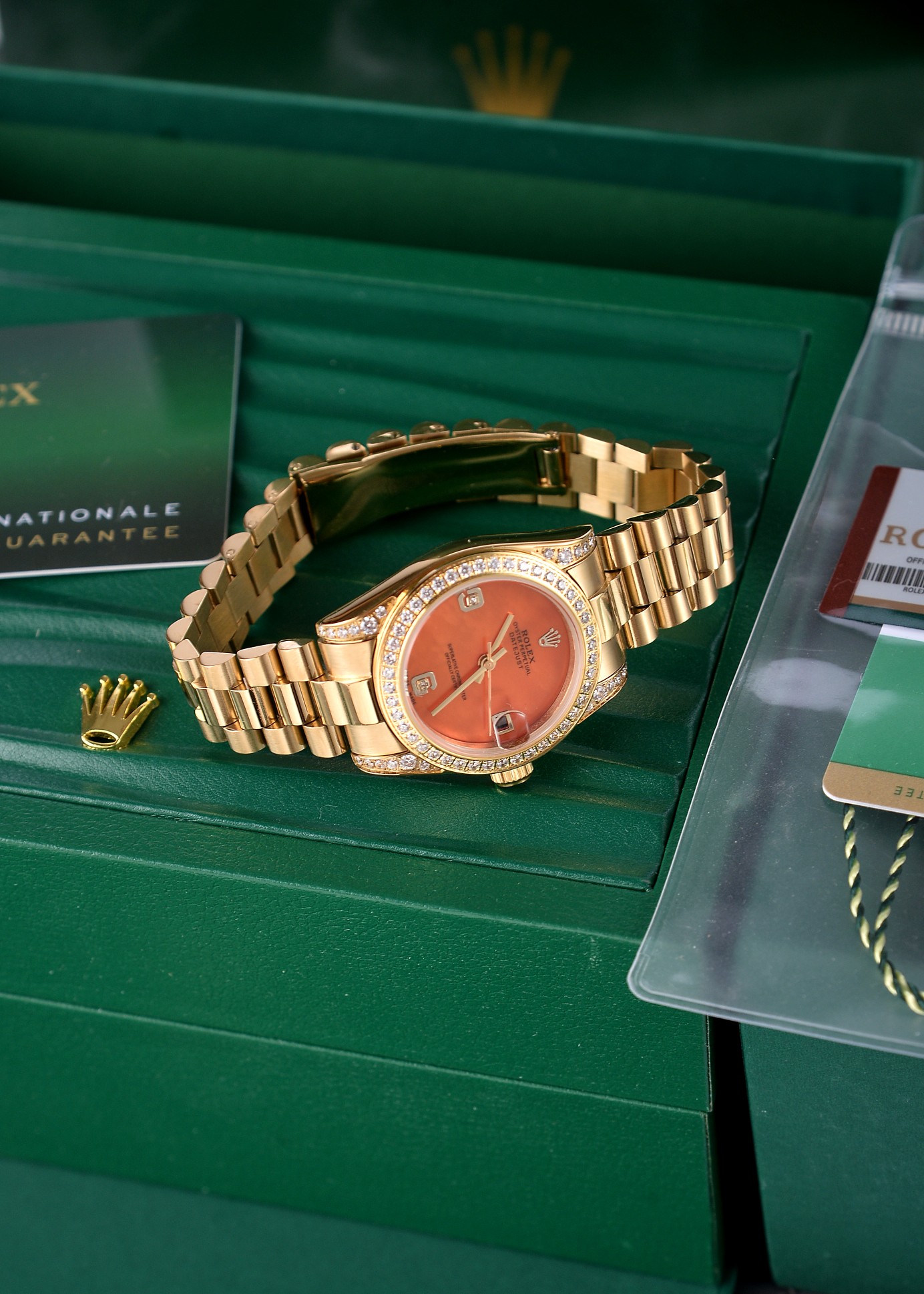 💰500🔰【珍珠贝母彩色表盘】【四耳位镶钻的腕表】，劳力士日志型（Datejust）31系列，是劳力士专为女性设计的经典款型。

核心特征与对应型号要点

1. 尺寸与材质

◦ 表径31mm，表壳多采用黄金/玫瑰金/黄金钢（蚝式钢+黄金）材质，

◦ 珍珠贝母表盘为天然材质，无人工着色，彩色盘面（粉、紫、橙、红等）均为贝母天然纹理与色泽，每枚表盘独一无二。

2. 镶钻与设计

◦ 四耳位（表耳）镶钻为定制/高端款特征，原厂基础款多为表盘刻度镶钻+外圈镶钻，表耳镶钻多为后镶钻或高级定制版。