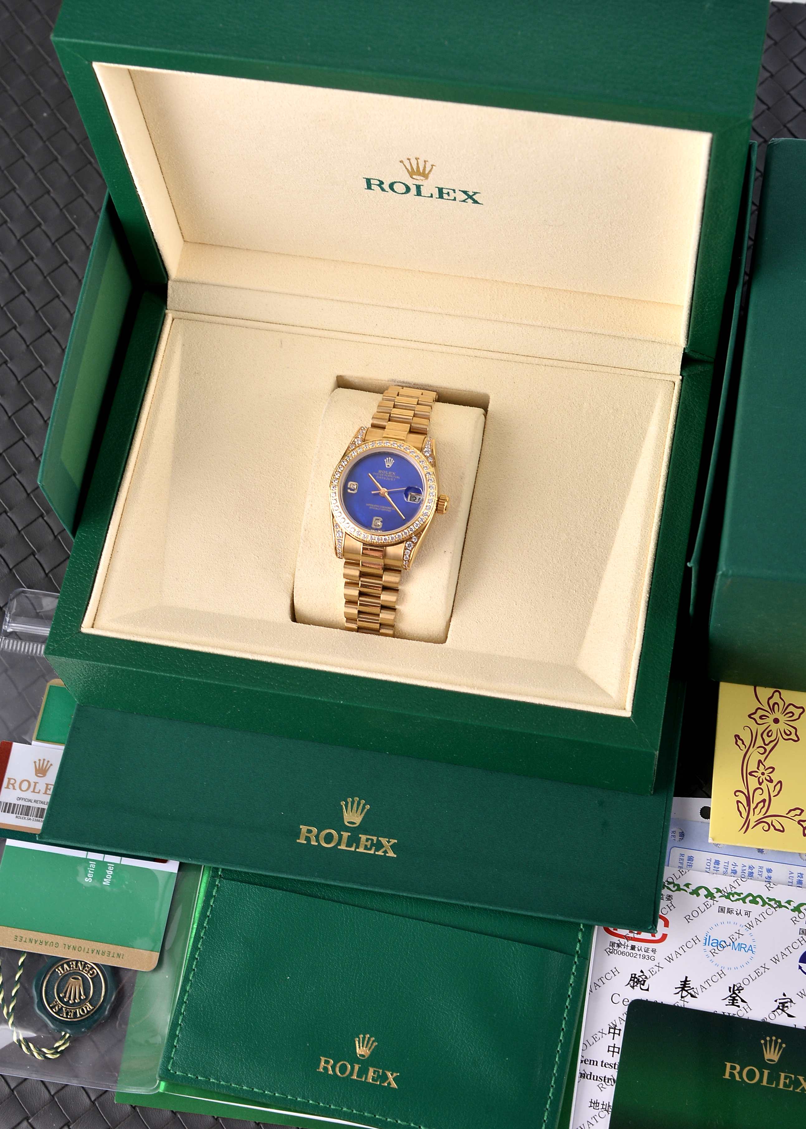 💰500🔰【珍珠贝母彩色表盘】【四耳位镶钻的腕表】，劳力士日志型（Datejust）31系列，是劳力士专为女性设计的经典款型。

核心特征与对应型号要点

1. 尺寸与材质

◦ 表径31mm，表壳多采用黄金/玫瑰金/黄金钢（蚝式钢+黄金）材质，

◦ 珍珠贝母表盘为天然材质，无人工着色，彩色盘面（粉、紫、橙、红等）均为贝母天然纹理与色泽，每枚表盘独一无二。

2. 镶钻与设计

◦ 四耳位（表耳）镶钻为定制/高端款特征，原厂基础款多为表盘刻度镶钻+外圈镶钻，表耳镶钻多为后镶钻或高级定制版。