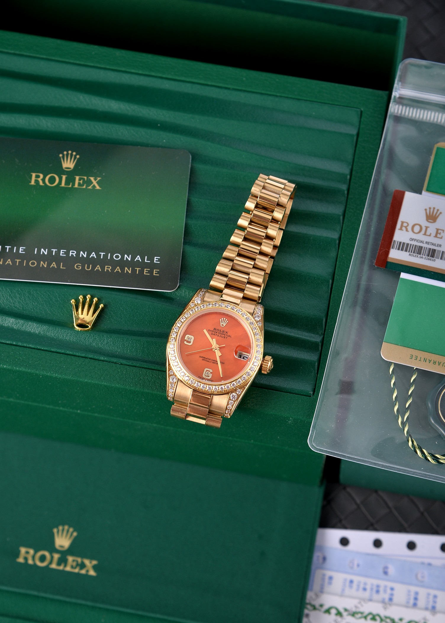 💰500🔰【珍珠贝母彩色表盘】【四耳位镶钻的腕表】，劳力士日志型（Datejust）31系列，是劳力士专为女性设计的经典款型。

核心特征与对应型号要点

1. 尺寸与材质

◦ 表径31mm，表壳多采用黄金/玫瑰金/黄金钢（蚝式钢+黄金）材质，

◦ 珍珠贝母表盘为天然材质，无人工着色，彩色盘面（粉、紫、橙、红等）均为贝母天然纹理与色泽，每枚表盘独一无二。

2. 镶钻与设计

◦ 四耳位（表耳）镶钻为定制/高端款特征，原厂基础款多为表盘刻度镶钻+外圈镶钻，表耳镶钻多为后镶钻或高级定制版。