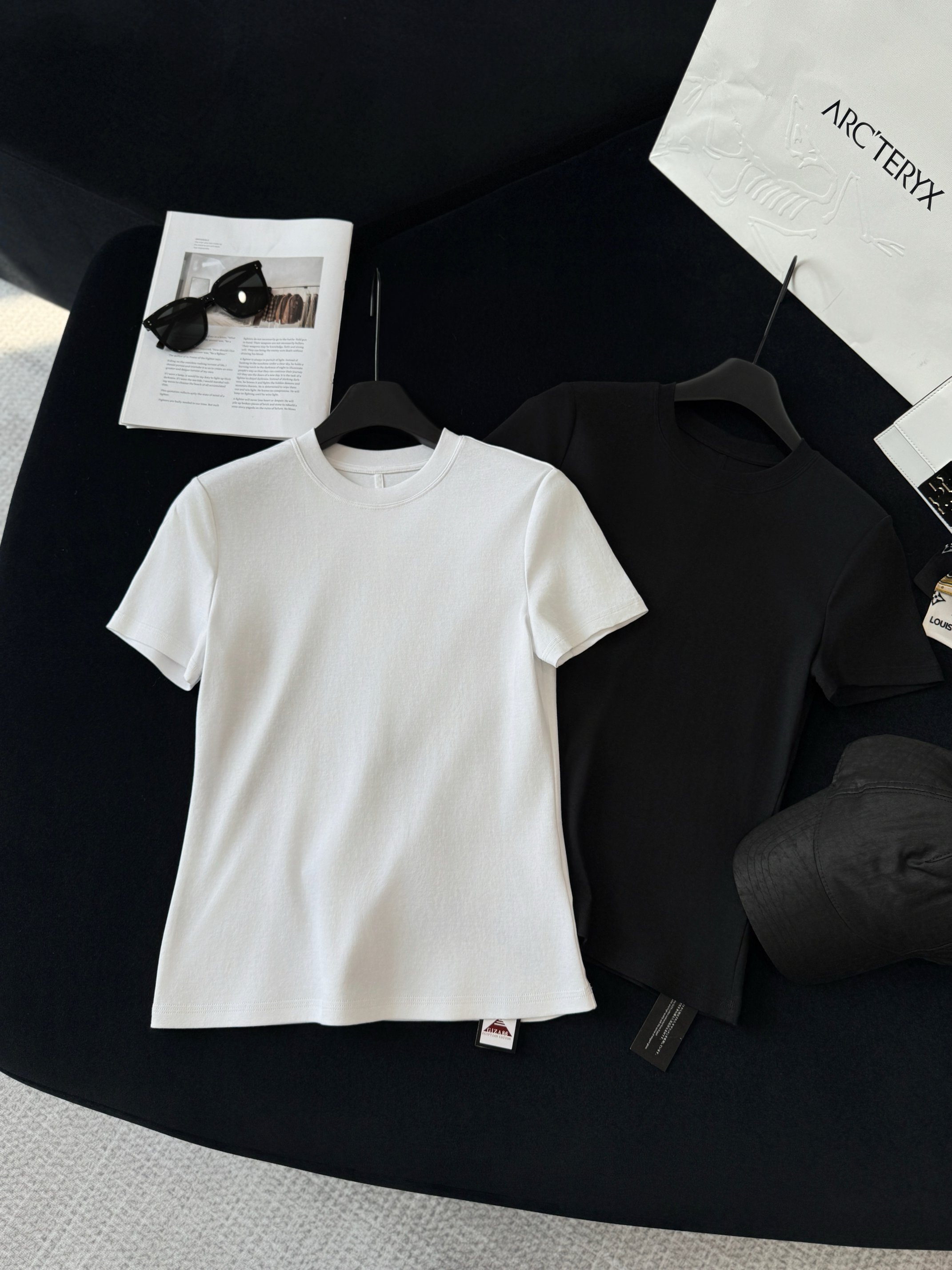 NO:444407,Production technology The neckline adopts French double-sided high-density ribs, and the negative tolerance is achieved by 12 pre-shrinking and setting treatments to achieve elastic accuracy of 0.3mm. The three-line needle sewing process is used for the short-sleeved hem and cuffs of the island cotton. The three needles are synchronized. The sewing process is made by Japanese JIS L0217-2015 machine, forming three parallel stitches, and the coupling of up and down curved needles is formed to form a dense mesh stitch structure. The wave-shaped three-wire chain stitch is reserved, and the stitch density is set to 4-5 needles per centimeter. The three-wire spacing is precisely calculated (usually 0.2-0.3cm gap), so that the suture forms a gradient bearing structure when under stress, and improves the tear resistance strength at the joints to more than 300N.,,T-shirt,alexander wang19860909生产工艺 领口采用法式双面高密罗纹,经12道预缩定型处理实现负公差0.3mm弹力精度. 海岛棉短袖下摆和袖口采用的三本针缝制工艺,三根机针同步作业,使用的是日本JIS L0217-2015机器缝制,形成三条平行线迹,配合上下弯针勾连形成致密网状线迹结构.波浪形三线链式线迹,预留0.5-1mm的伸缩余量,线迹密度设置为每厘米4-5针,三线间距经过精密计算（通常0.2-0.3cm间距差）,使缝线在受力时形成梯度承力结构,提升接缝处抗撕裂强度达300N以上.,,T-shirt,alexander wang,Women's clothing