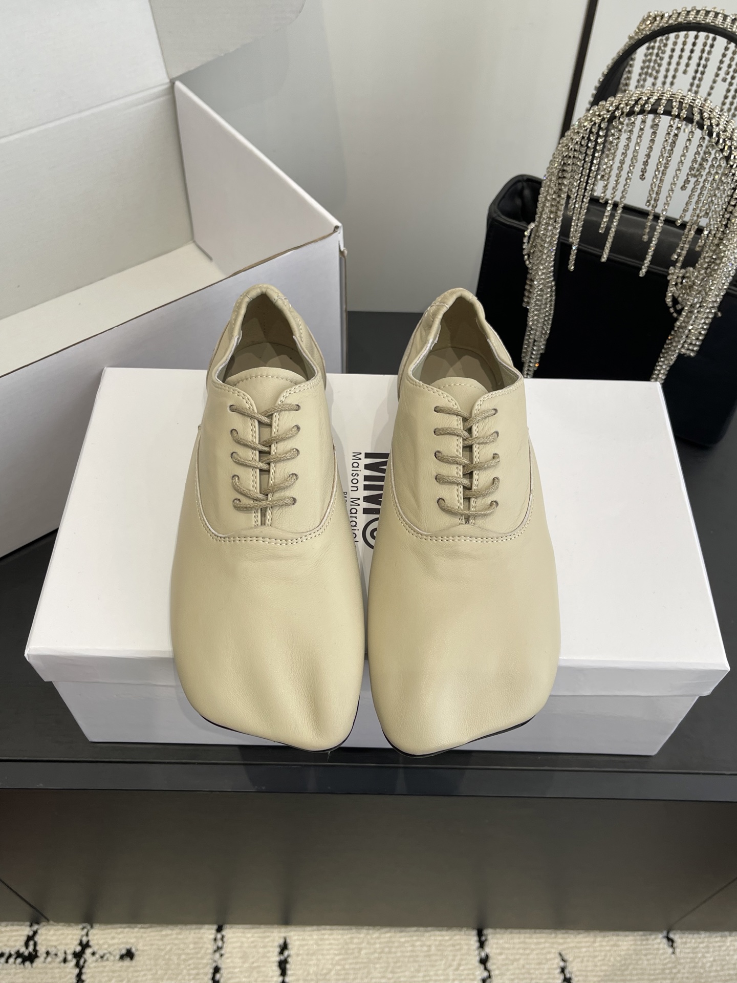 NO:789397,Maison Margiela MM6 26ss early spring new square-toe lace-up flat casual shoes combine the soft silhouette of ballet shoes with the lace-up structure of Oxford shoes. The toe is an iconic square toe design, with simple and sculptural lines, breaking the boundaries of traditional shoe styles. Made of fine soft leather, the upper has no stiff splicing, the texture is soft and fits the foot, and the stitching process of the shoe body is exquisite, continuing the brand's exquisite attention to material texture.  The basic black and white color scheme is more adaptable and meets different matching needs. It implements Maison Margiela's iconic 'deconstruction', simplifies the functional decoration of shoes, retains the core wearing experience, and is both artistic and practical. Imported sheepskin upper, sheepskin lining, genuine leather outsole, size 35-40 (customized in 40), single shoes, masion margiela, flats, sheepskin, Leather soles19860909Maison Margiela MM6 26ss早春新品方头系带平底鞋休闲鞋 融合芭蕾鞋的柔软廓形与牛津鞋的系带结构,鞋头为标志性的方头设计,线条简约且具雕塑感,打破传统鞋型的边界感.采用细腻的软质皮革打造,鞋面无生硬拼接,质感柔软贴合脚部,鞋身缝线工艺精致,延续品牌对材质肌理的考究. 基础黑白色系则适配性更强,满足不同搭配需求.贯彻 Maison Margiela 标志性的“解构主义”,简化鞋履的功能性装饰,保留核心穿着体验,兼具艺术感与实穿性. 鞋面进口羊皮 内里羊皮 大底真皮大底 码数35-40（40订做）,单鞋,masion margiela,flats,sheepskin,Leather soles,Women's Shoes