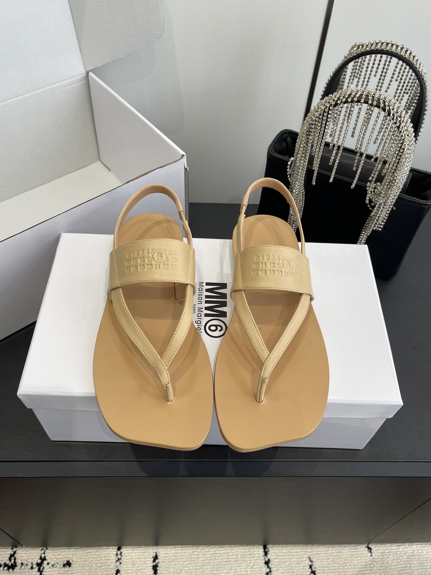 NO:789391,Maison Margiela MM6 26ss spring and summer new flip-flop back strap sandals break the rounded shape of traditional flip-flops and adopt a square toe + clip feet + back strap design. The back strap is adjustable for comfort and wrapping; minimalist lines and geometric square toes create a pioneering deconstructive style, suitable for daily leisure, street fashion and other scenes. MM6 Maison is embossed on the ankle strap.  Margiela brand letter logo, the brand's classic MM6 logo and the full name of the brand are printed on the inside of the shoe box. The low-key embossing process is in line with the brand's minimalist and deconstructed design tone, strengthening brand recognition. Sheepskin upper, sheepskin lining, genuine leather outsole, size 35-40 (customized in 40), split-toe shoes, masion margiela, sandals, sheepskin, Leather soles19860909Maison Margiela MM6 26ss春夏新款人字拖后绊带凉鞋 打破传统人字拖的圆润版型,采用方头+夹脚+后绊带设计,后绊带可调节,兼顾舒适度与包裹性；极简的线条搭配几何感方头,打造出先锋的解构主义风格,适配日常休闲、街头潮搭等场景. 脚踝绊带处压印MM6 Maison Margiela品牌字母标识,鞋盒内侧印有品牌经典的MM6 logo与品牌全称,低调的压印工艺契合品牌极简、解构的设计调性,强化品牌辨识度. 鞋面羊皮 内里羊皮 大底真皮大底 码数35-40（40订做）,分趾鞋,masion margiela,sandals,sheepskin,Leather soles,Women's Shoes