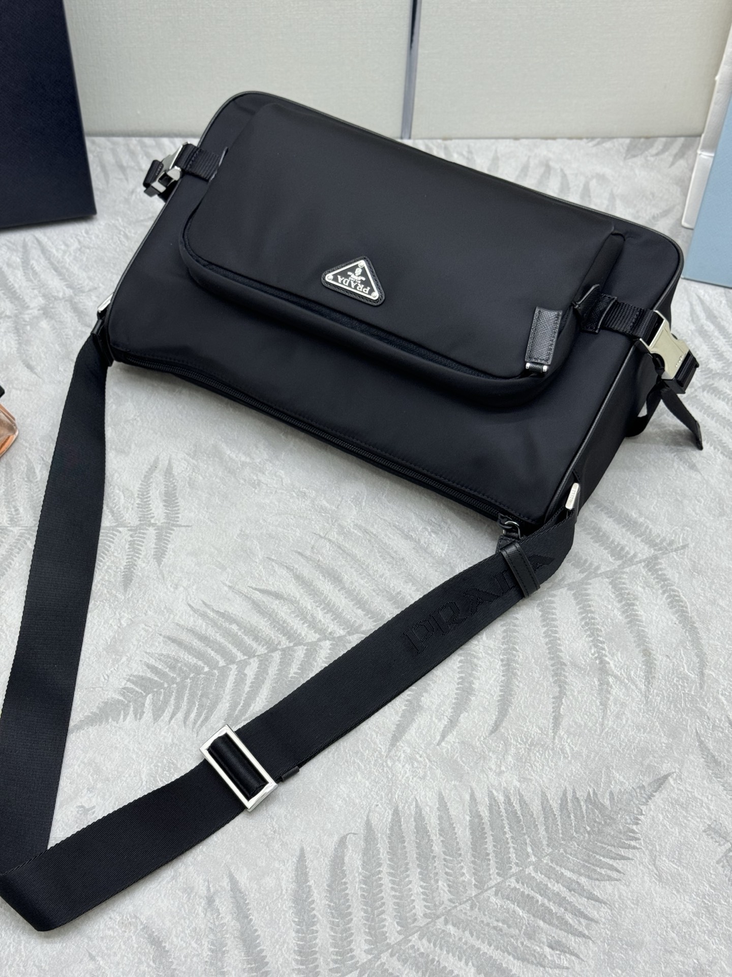 P410，🎉新款大号邮差包🎉🎉2VH191大号🎉🎉
这款单肩包的运动功能性由简约线条和实用现代细节定义。包身采用创新性的Re-Nylon再生尼龙材质打造，搭配Saffiano牛皮革细节，增添独特精致气息。多功能风格融合标志性元素，饰以涂珐琅金属三角形徽标，容量空间大，又是一款永久不过时爆款，赶紧入手吧🎉🎉
尺寸:长35x高22x底12cm(此款大，不配包装)