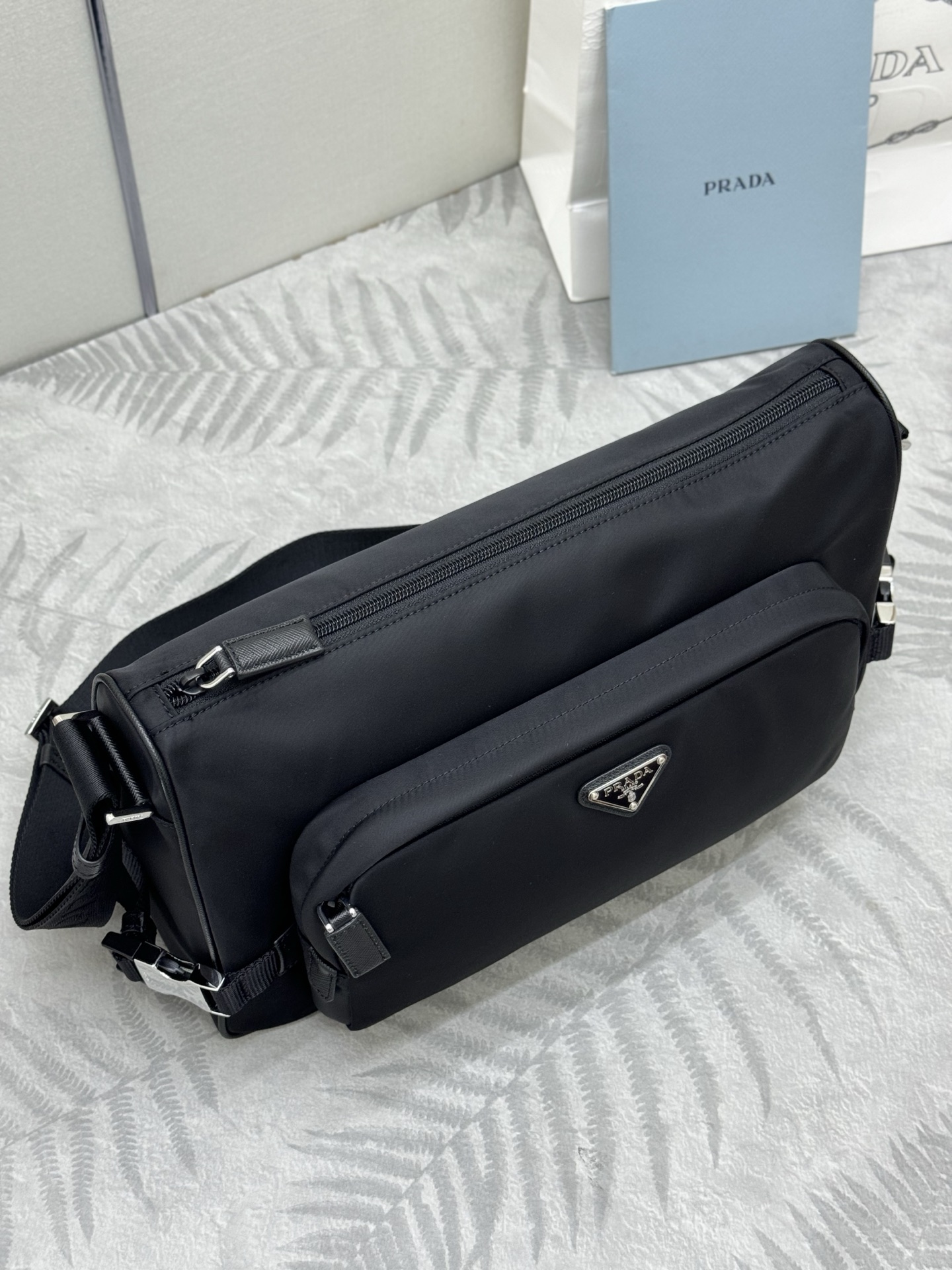 P410，🎉新款大号邮差包🎉🎉2VH191大号🎉🎉
这款单肩包的运动功能性由简约线条和实用现代细节定义。包身采用创新性的Re-Nylon再生尼龙材质打造，搭配Saffiano牛皮革细节，增添独特精致气息。多功能风格融合标志性元素，饰以涂珐琅金属三角形徽标，容量空间大，又是一款永久不过时爆款，赶紧入手吧🎉🎉
尺寸:长35x高22x底12cm(此款大，不配包装)