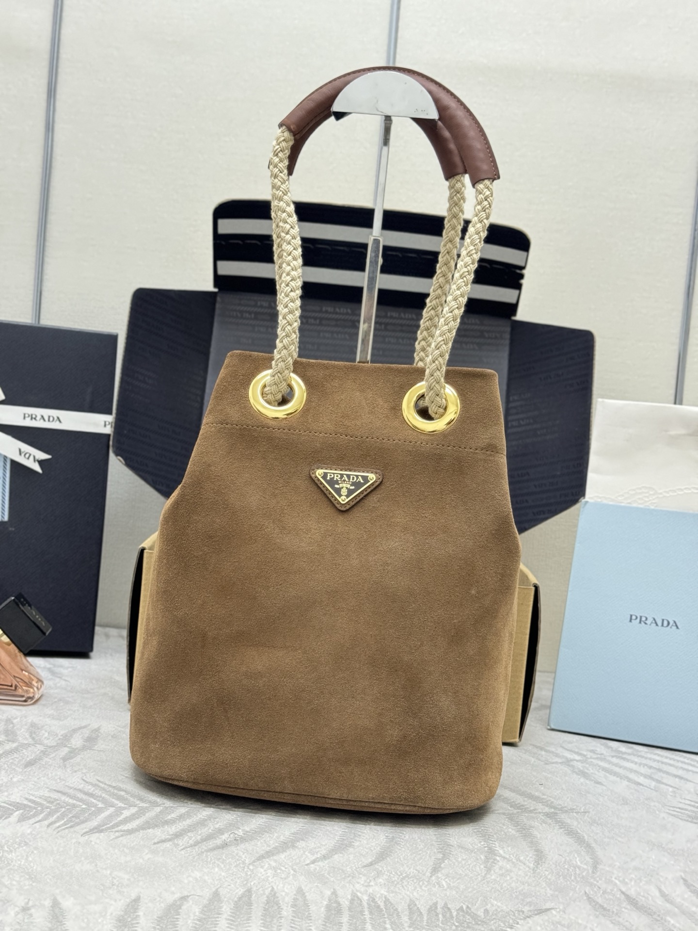 NO:390057,.New Frosted Water Bucket Bag 1BE082 Suede Frosted Brown The design of this Re-Nylon handbag is made of imported suede fabric and calfskin. The unique combination is charming. The sliding rope hand-held highlights the flexibility and versatility of this handbag, which is convenient for carrying or shoulders/slanting spans, top-grade hardware. Large capacity and space, very casual and fashionable, and it is another permanent outdated hot model. Babies, hurry up and buy it. Size: 23.5x long and 28x bottom 16.5cm, Prada [top original list], prada, cowhide, chamois leather19860909.新款磨砂水桶包1BE082麂皮磨砂棕色 这款Re-Nylon 手袋的設計采用进口麂皮面料和小牛皮.獨特的組合添上迷人點綴.滑動式繩索手挽凸顯這款手袋的靈活百搭,方便手提或肩背/斜跨,顶级五金.容量空间大,非常休闲时尚,又是一款永久不过时爆款,宝宝们,赶紧入手吧 尺寸:长23.5x高28x底16.5cm,普拉达【顶级原单】,prada,cowhide,chamois leather,Bag