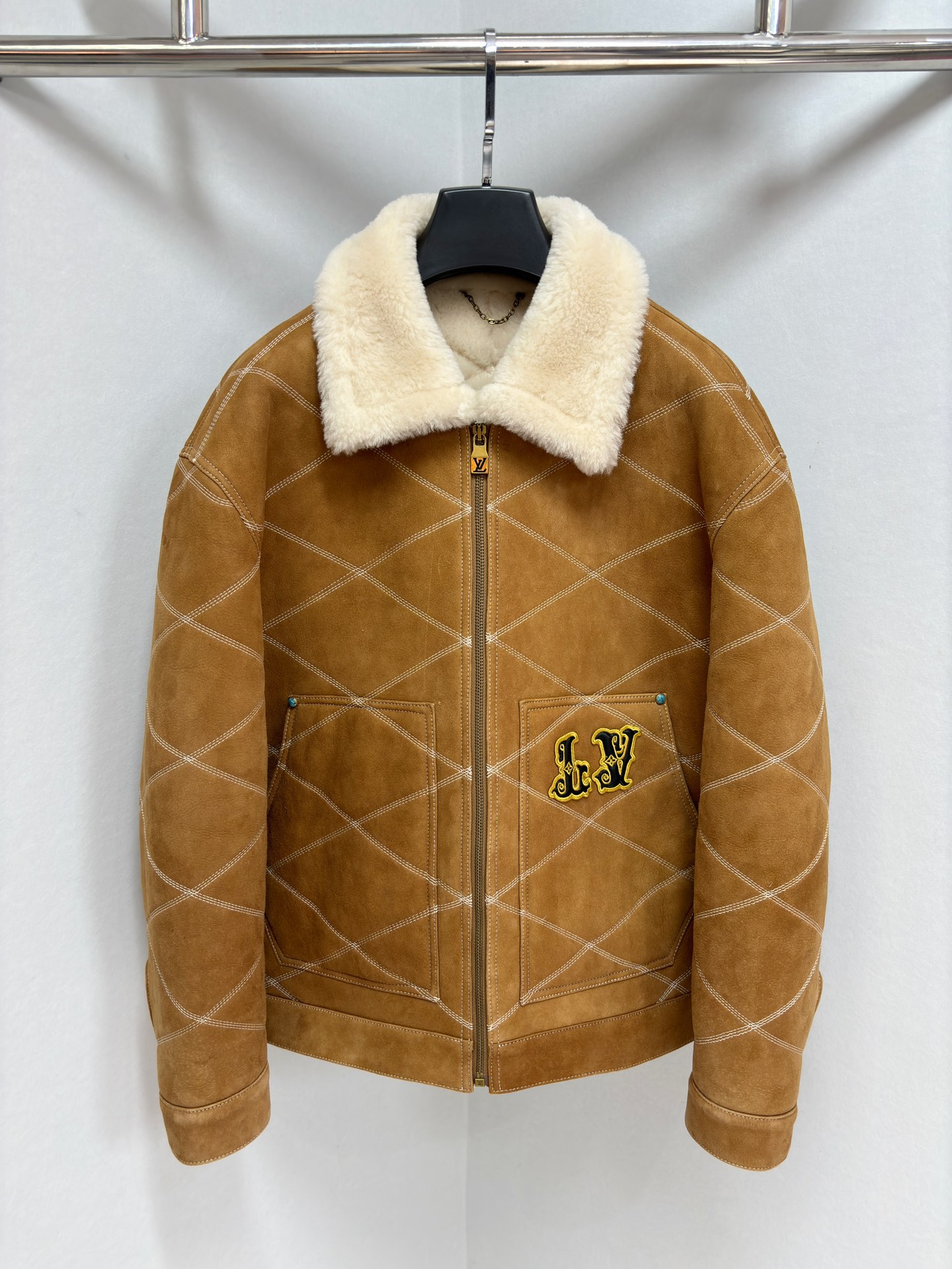 NO:674856,1V Men's Embroidered (Sheepskin) Work Tunic Jacket This shearling leather tunic jacket uses exquisite craftsmanship to construct a casual silhouette, with full-width diamond stitching to pay tribute to the lining design of the brand's traditional hard luggage. It is embellished with retro padded embroidered leather LV and Louis Vuitton patches on the front and back, highlighting the Far West theme of the autumn and winter show, and buttons and rivets add a sophisticated touch. Casual fit. The front left pocket shows a padded embroidered LV patch.  Padded embroidered Louis Vuitton patch at rear Wool leather collar and lining Zip at front with LV stamped zipper pull Buttons and rivets Sizes 48-56,,louis vuitton,louis vuitton,jackets & coats,sheepskin,Top Customize1198609091V 男装刺绣（羊皮毛一体）工装束腰夹克 本款羊毛皮革束腰夹克采用精湛匠艺构筑休闲廓形,以全幅菱格缝线致敬品牌传统硬箱的内衬设计.前后点缀复古加衬刺绣皮革 LV 和路易威登贴饰,点明 秋冬秀场的 Far West 主题,纽扣和铆钉再添考究气息. 休闲版型 正面左侧口袋呈现加衬刺绣 LV 贴饰 后部呈现加衬刺绣路易威登贴饰 羊毛皮革衣领和内里 拉链前襟配有 LV 铭纹拉链头 纽扣和铆钉 尺码48-56,,louis vuitton,louis vuitton,jackets & coats,sheepskin,Top Customize1,Men's clothing