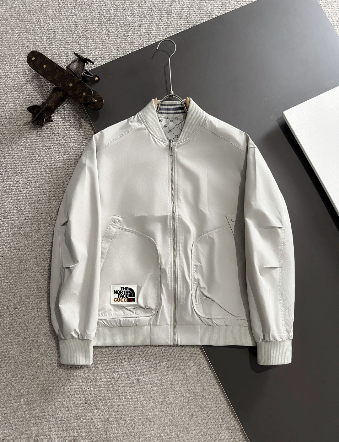 Envío al día siguiente Chaqueta cortavientos con capucha y cremallera de la colección conjunta Gucci x North Face, prim…