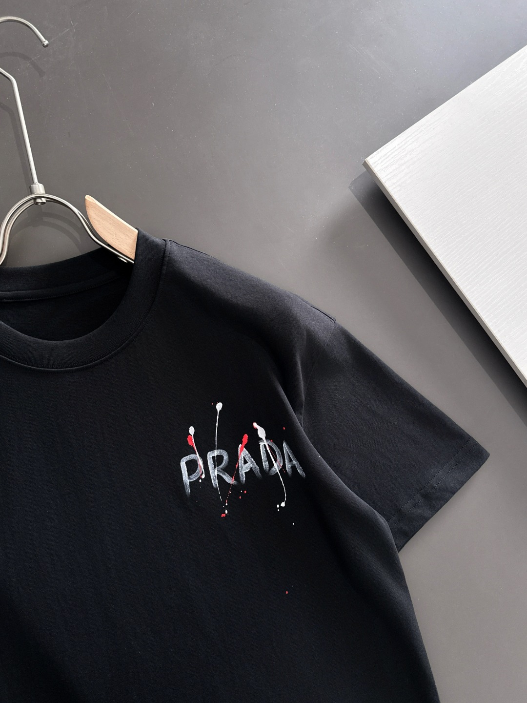 隔天出货 P125 普拉达 2026夏季新款  （顶级品质 区别通货）
重磅推出特殊面料短袖 
夏季走秀款 个性独家款式 男女同款 采用进口定制定染面料 后领锁链底全包肩 过水不变形不缩水 
SIZE：M到3XL