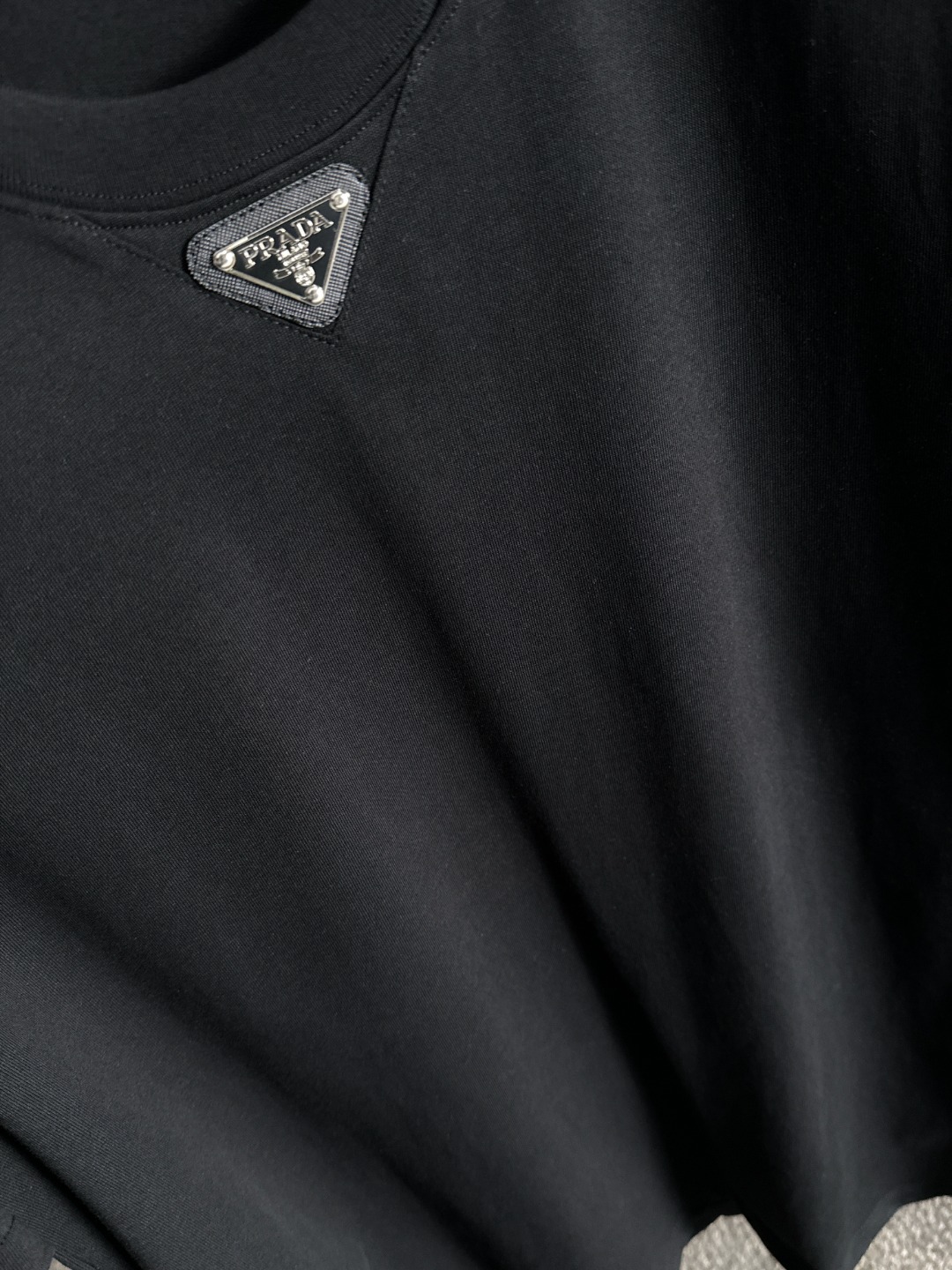 隔天出货 P125 普拉达 2026夏季新款  （顶级品质 区别通货）
重磅推出特殊面料短袖 
夏季走秀款 个性独家款式 男女同款 采用进口定制定染面料 后领锁链底全包肩 过水不变形不缩水 
SIZE：M到3XL