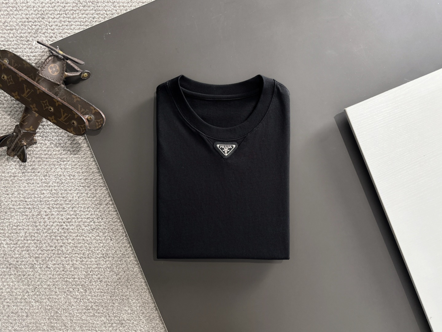 隔天出货 P125 普拉达 2026夏季新款  （顶级品质 区别通货）
重磅推出特殊面料短袖 
夏季走秀款 个性独家款式 男女同款 采用进口定制定染面料 后领锁链底全包肩 过水不变形不缩水 
SIZE：M到3XL