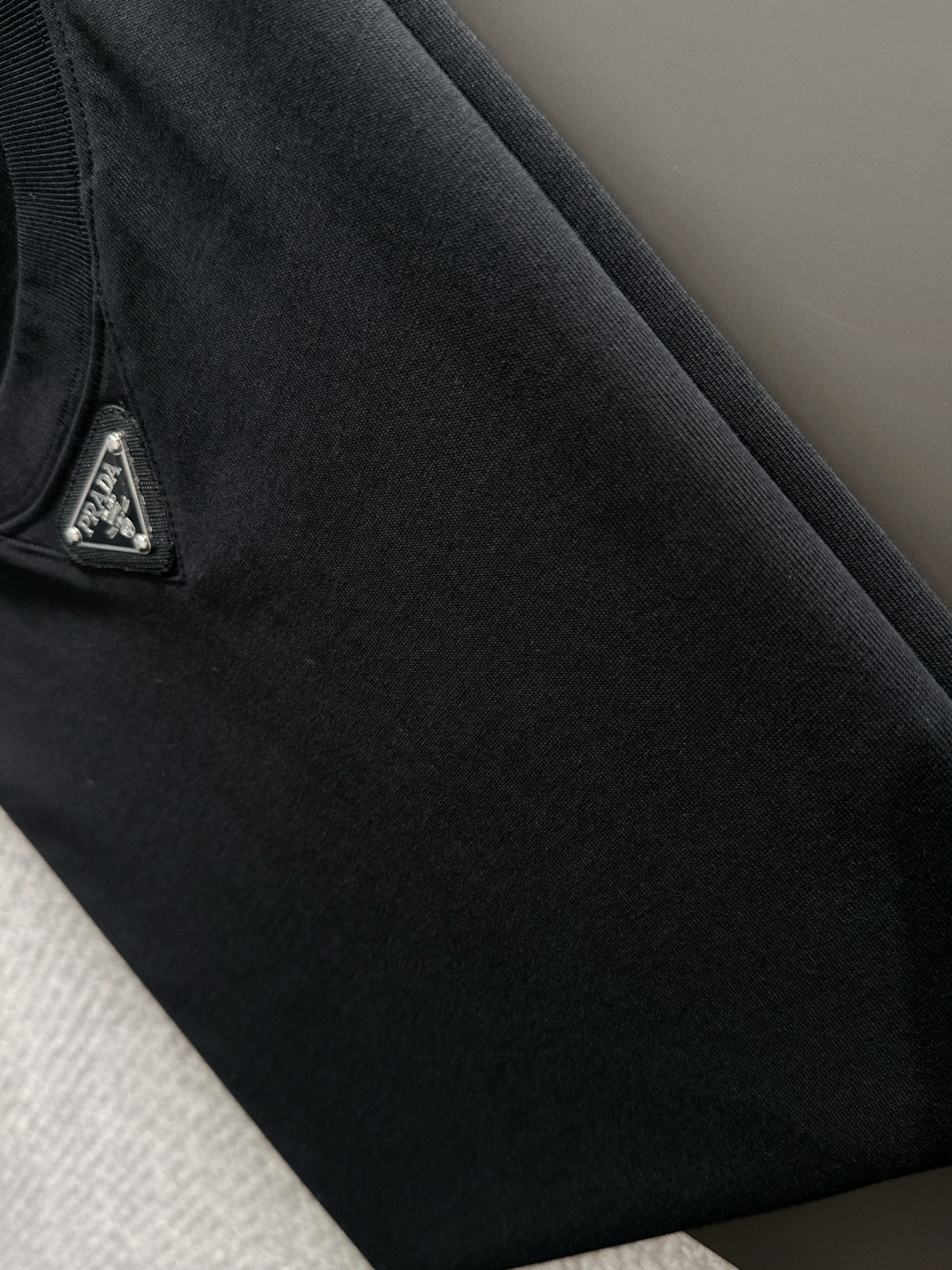 隔天出货 P125 普拉达 2026夏季新款  （顶级品质 区别通货）
重磅推出特殊面料短袖 
夏季走秀款 个性独家款式 男女同款 采用进口定制定染面料 后领锁链底全包肩 过水不变形不缩水 
SIZE：M到3XL