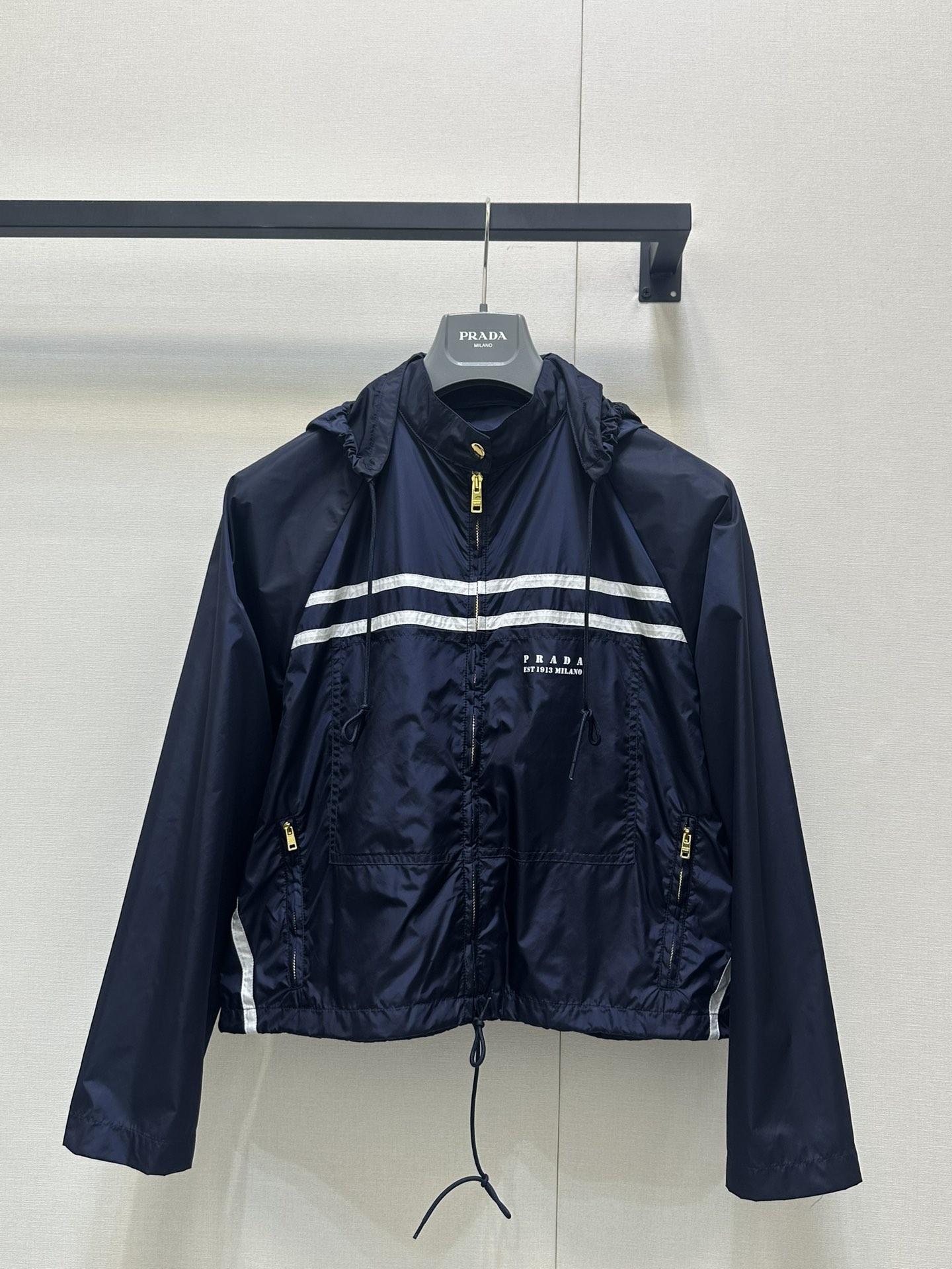 NO:427148,(Coat) Prad* 25Ss Spring and Summer New Style Removable Hooded Sunscreen Jacket Jacket + Zipper Skirt. Original Developed!  High-end production!  The imported recycled nylon fabric is made of excellent texture and breathable. The simple and smooth lines outline the neatly styled, and the stand-up collar design adds a bit of heroic spirit. The iconic double white stripes run across the chest, like the guide line on the track, eye-catching and dynamic, instantly breaking the monotony and becoming the visual focus. The exquisite zipper is smooth and the details show quality; the hem drawstring design freely adjusts the elasticity and adapts to different outfit needs, and can be easily controlled whether it is sports or fitness or walking on the street. Spot SML real-time photos, prada, skirts, jackets & coats, jackets & coats, hats, alexander wang19860909（外套） Prad* 25Ss春夏新款 可拆卸连帽防晒夹克外套+拉链半裙.原版开发！高版出品！采用进口再生尼龙面料,质感上乘,透气性佳.简洁流畅的线条,勾勒利落版型,立领设计增添几分飒爽英气.标志性双白条纹横贯胸前,似赛道上的指引线,醒目又充满动感,瞬间打破单调,成为视觉焦点.精致拉链开合顺滑,细节处彰显品质；下摆抽绳设计,自由调节松紧,适配不同穿搭需求,无论是运动健身,还是街头漫步,都能轻松驾驭.现货 SML大货实拍,,prada,skirts,jackets & coats,jackets & coats,hats,alexander wang,Women's clothing