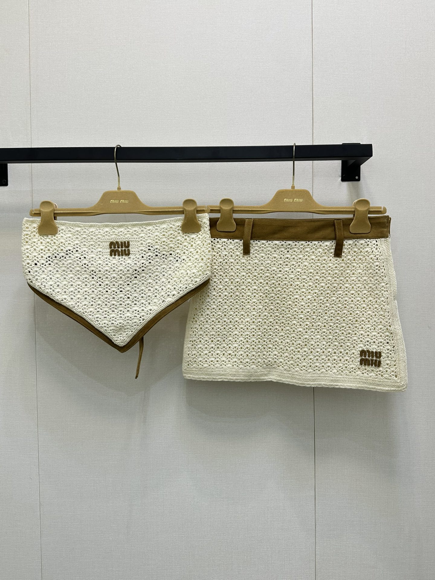 NO:441919,(skirt)) Miu Miu 2025 summer new product set, integrating weaving technology into the design. The top and bottom are hollowed-woven leather fabric, presenting a light and breathable texture, while cleverly matching brown trim at the edges to form a visual sense of layering and exquisiteness. The brand's iconic 'MIU MIU' letter logo embellishes it, highlighting the brand's unique style and recognition. Whether you are enjoying the sunny beach during vacation or walking on the streets of the city, this outfit allows you to show a casual and elegant fashion attitude, easily becoming the focus of everyone's attention. Identify my version SML large-scale real shots, miumiu, skirts, alexander wang19860909（半裙）） Miu Miu 2025 夏季新品套装,将编织工艺融入设计.上衣与下装采用镂空编织真皮面料 呈现出轻盈透气的质感,同时在边缘处巧妙搭配棕色饰边,形成视觉上的层次感与精致感.品牌标志性的 “MIU MIU” 字母标识点缀其上,彰显品牌独特的风格与辨识度.无论是在度假时享受阳光沙滩,还是在都市街头漫步,这套服装都能让你展现出随性又不失优雅的时尚态度,轻松成为众人瞩目的焦点 认准我家版本 SML大货实拍,,miumiu,skirts,alexander wang,Women's clothing
