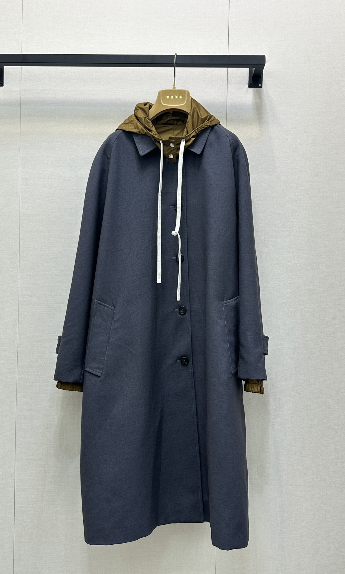 NO:446073,Miumiu25 early autumn new fake two-family windbreaker design contrasting color hat design, hat can be detached, gray-tuned coat has a slack feeling, hooded design combines casualness and casualness, contrasting color lining adds layering. The buttons are neatly arranged, and the pockets hide a little lazy, and the long style is suitable for a variety of styles. It is a fashionable 'armor' that can accompany you through different seasons, easily covering the relaxed atmosphere~ Fashionable essence must be entered~ Identify my version SML large-scale real shot, miumiu, hats, alexander wang19860909Miumiu25早秋新款假两家风衣 撞色帽子设计 帽子可拆卸 灰调大衣自带松弛感,连帽设计糅合休闲与随性,撞色内衬添层次.纽扣排列利落,口袋藏起小慵懒,长款版型适配多种风格,单穿或叠搭都很出彩,是能陪你走过不同季节的时尚「铠甲」,轻松罩住松弛氛围~ 时髦精必入～认准我家版本 SML大货实拍,,miumiu,hats,alexander wang,Women's clothing