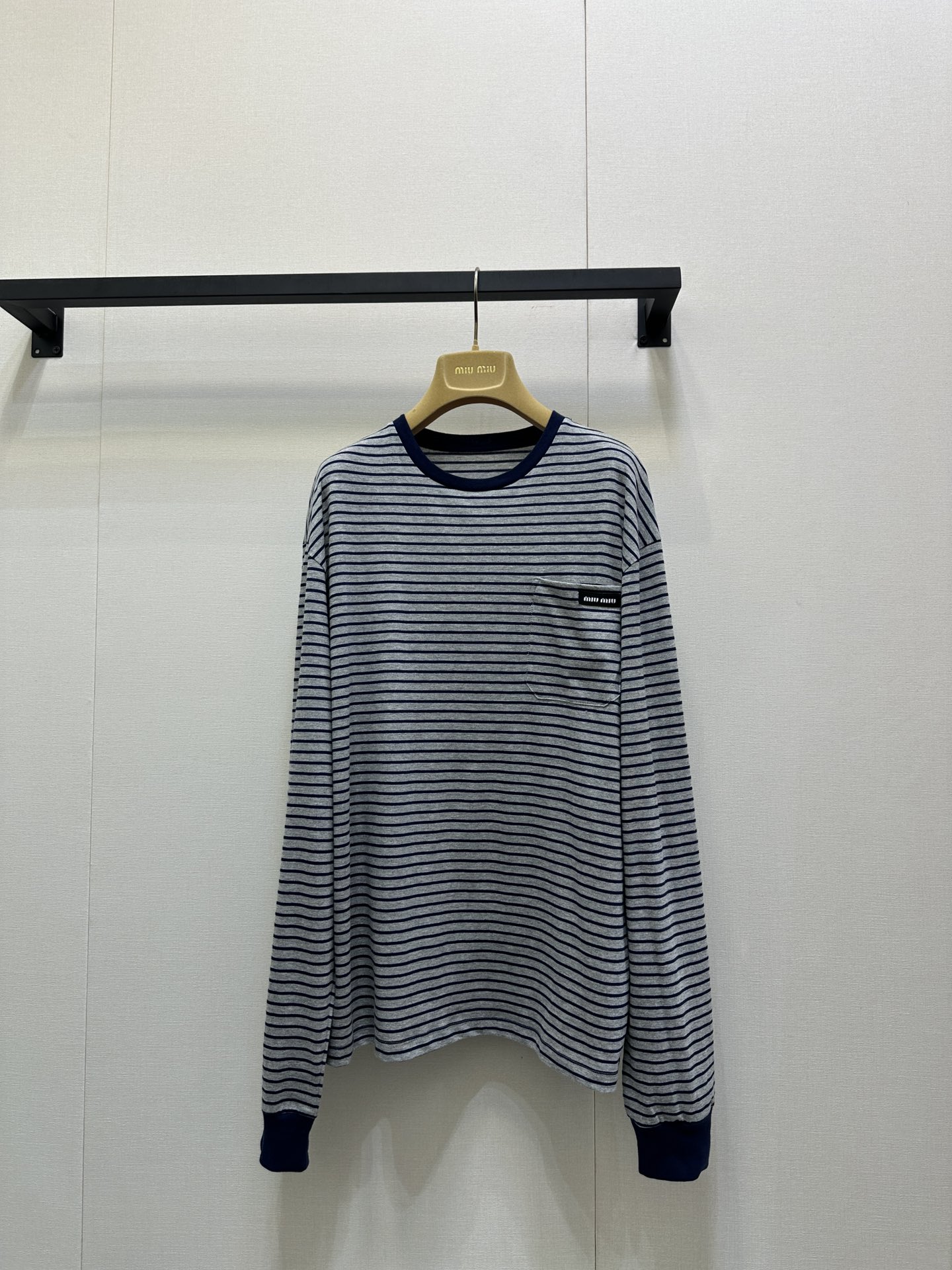 NO:548991,MiuMi* 25FW early autumn new model, basic style narrow stripes, logo long sleeves, T-shirt丨Original development!  High-end production!  With the gray-bottomed hidden blue pinstripes as the core, the retro academy style is blowing; the neckline and cuffs are embellished with hidden blue ribs, neat and layered. The black-bottomed white-lined small logo on the left chest is low-key to show the brand identity. The pure cotton fabric is soft and skin-friendly, and the loose shoulder-loose style is highly inclusive for the figure, truly achieving the same versatility of men and women. The precise striped alignment process takes time and materials, and restores the exquisite texture of the brand from the details. It can be adapted to both single-wearing and layering or commuting leisure. It can be called the 'evergreen basic style' in the four-season wardrobe. S/M/L large-scale real-time photo shoot, miumiu, alexander wang19860909MiuMi* 25FW早秋新款 基础款窄条纹 logo长袖 T 恤丨原版开发！高版出品！以灰底藏蓝细条纹为核心,复古学院风扑面而来；领口与袖口点缀藏蓝罗纹,利落又具层次感.左胸处黑底白字小标低调彰显品牌身份, 纯棉面料柔软亲肤,宽松落肩版型对身材包容性极强,真正实现男女同款百搭.条纹精准对位工艺耗时费料,从细节处还原品牌精致质感,无论是单穿叠搭还是通勤休闲都能适配,堪称四季衣橱里的“常青基础款”.现货发售S/M/L大货实拍,,miumiu,alexander wang,Women's clothing