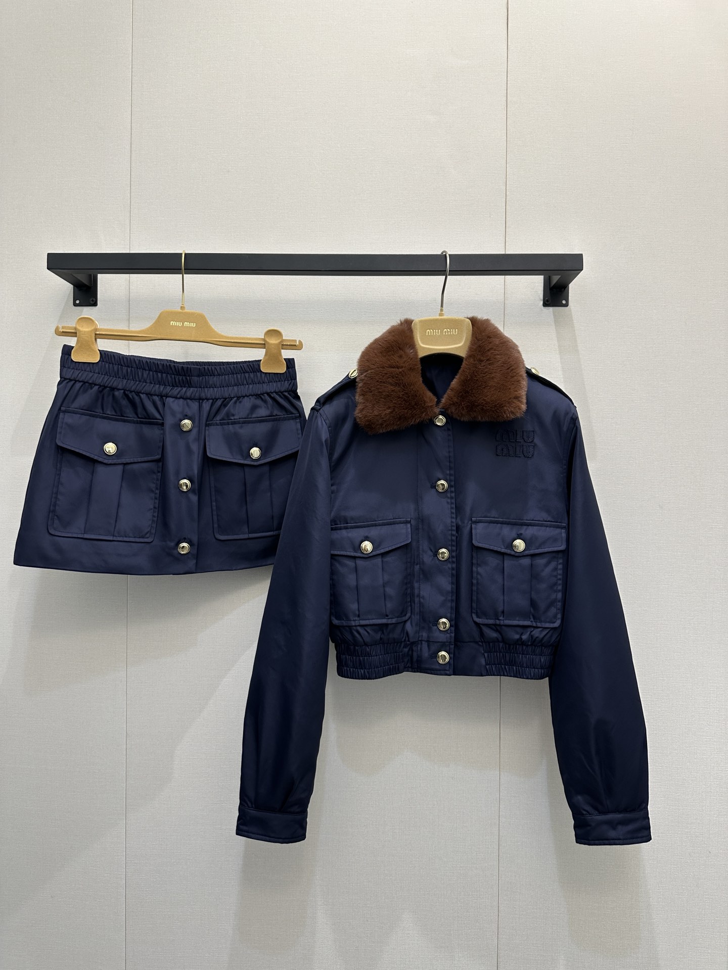 NO:591750,Jacket MiuMi* 25 new autumn and winter style lapel short tunic jacket + skirt suit丨original development!  High quality production!  The matte satin nylon fabric is selected, with a low-key soft luster, and a sense of stiffness and drape; the interior is quilted and filled, taking into account both autumn and winter warmth and a light silhouette; the lapel is spliced with plush material, giving it a warm atmosphere; the chest stands  Body work pockets + gilt metal buttons, full of retro feel; high-waisted design of the same fabric, with symmetrical work pockets and gilt buttons, echoing the details of the jacket; the skirt is short but not cramped, taking into account both girlishness and daily practicality!  Ready sale S/M/L large goods, real shots,,miumiu,skirts,jackets & coats,jackets & coats,alexander wang19860909外套 MiuMi* 25秋冬新款 翻领短款束腰夹克+半裙套装丨原版开发！高版出品！甄选哑光缎面尼龙面料,自带低调柔润光泽,挺括度与垂坠感兼具；内里夹棉填充,兼顾秋冬保暖性与轻盈廓形；翻领拼接毛绒材质,自带温暖氛围；胸前立体工装口袋+金属鎏金纽扣,复古感拉满；同面料高腰设计,搭配对称工装口袋与鎏金纽扣,与夹克细节呼应；裙型短而不局促,兼顾少女感与日常实穿性！现货发售S/M/L大货实拍,,miumiu,skirts,jackets & coats,jackets & coats,alexander wang,Women's clothing