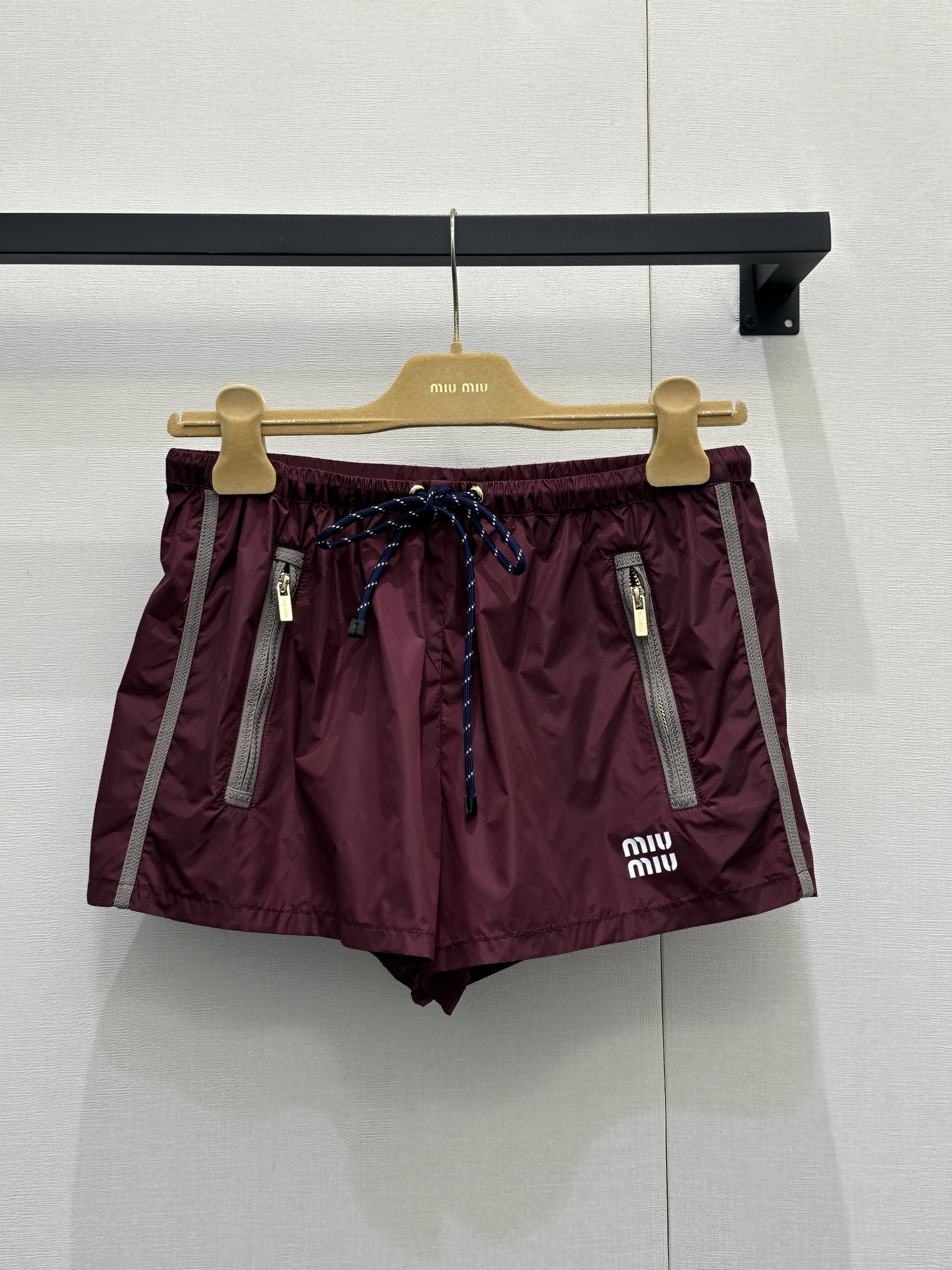 NO:708860,(Shorts) Miu26 new and latest hooded jacket shorts suit  Customized YB eco-friendly regenerated nylon material, with glossy texture and stylish wear, hooded zipper jacket elastic shorts, the body is made of burgundy as the base, embellished with blue cable drawstrings, the drawstring and zipper details of the hooded jacket are full of design, loose fit  It hides the flesh and is casual. It is paired with shorts of the same color. The thin fabric is breathable and comfortable. The small logo on the chest is low-key embellishment. It is easy to control the upper body to create an outfit that combines girlishness and street style. Wear it out on the street and it will turn heads. Customized fabrics and accessories  Look for the correct version, high version, burgundy, real shots of large quantities,,miumiu,shorts,jackets & coats,hats,19860909（短裤） Miu26全新最新 款连帽外套短裤套装 定制YB环保再生尼龙材质,质感光泽,穿搭有型,连帽拉链外套弹力短裤,大身以酒红色为基底,点缀蓝色绞花抽绳,连帽外套的抽绳与拉链细节设计感拉满,宽松的版型藏肉又随性,搭配同色系短裤,轻薄的面料透气又舒适,胸口的小logo低调点缀,一套上身轻松拿捏少女感与街头感兼具的穿搭氛围,出街穿它回头率爆表.定制面辅料 认准版本 高版本 酒红 大货实拍,,miumiu,shorts,jackets & coats,hats,,Women's clothing