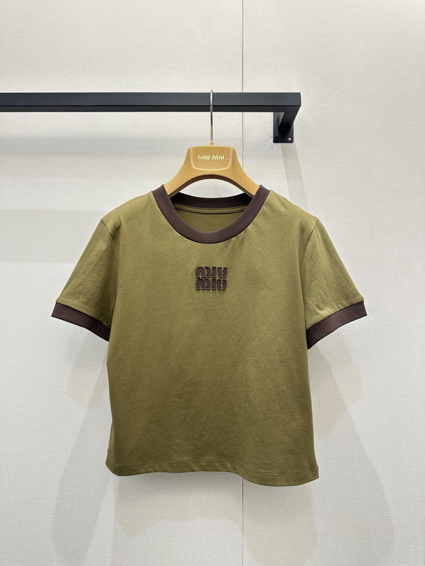 NO:712846,Miu M*u 26Ss early spring new contrasting color short round neck short-sleeved T-shirt丨Exclusively developed!  Top quality production!  With retro earth tones as the main tone, the dark brown contrasting round collar and cuffs form a visual hierarchy, fully displaying the brand's girly sweet and cool aesthetics. Selected high-quality cotton fabrics are soft and breathable to the touch, and have excellent skin-friendly properties; the short cut fits the body shape, naturally outlines the waistline, and optimizes body proportions.  The three-dimensional logo embroidery on the chest is exquisitely crafted, injecting a light luxury texture into the basic style. It is the core item for creating diverse looks in early spring. S/M/L available in stock, large quantities, real shots, miumiu, T-shirt, tees, t-shirt,19860909Miu M*u 26Ss早春新款撞色短款圆领短袖T恤丨独家开发！顶级高版出品！以复古大地色系为主调,深棕撞色圆领与袖口形成视觉层次,尽显品牌少女甜酷美学.精选优质棉质面料,触感柔软透气,亲肤性优异；短款剪裁贴合身形,自然勾勒腰线,优化身材比例.胸前立体logo刺绣工艺精致,为基础款注入轻奢质感,是早春打造多元造型的核心单品.现货发售S/M/L大货实拍,,miumiu,T-shirt,tees，t-shirt,,Women's clothing