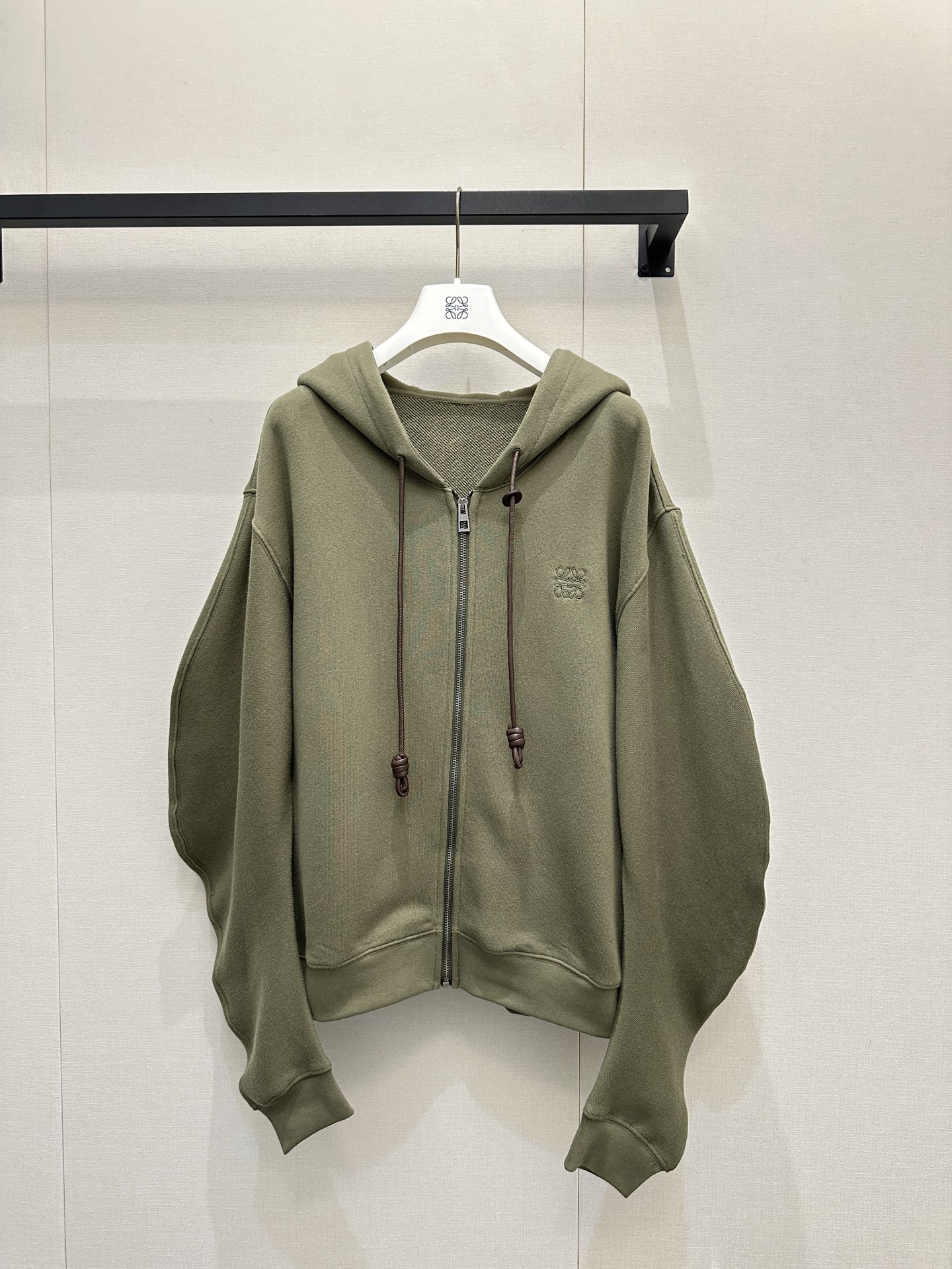 NO:713372,Loewe's top-quality sweatshirt jacket is made of high-count pure cotton fabric. It has a soft skin-friendly touch and moderately stiff silhouette support. It is breathable and not sweaty, suitable for many seasons. Customized front and center zippers. Elastic rib material on the cuffs and feet enhances the stability of the shape and is not easy to deform after long-term wear. The topstitching process on the bone seams enhances the overall sophistication, and the lines are neat and not bloated. The collar has eyelets inserted into the leather drawstring.  The leather rope texture and the pure cotton fabric form a material contrast with luxurious details. The sleeves are cut with three-dimensional scimitars, retaining the looseness of the casual sweatshirt, and the shoulder and arm proportions are modified through lines. The brand logo on the chest is embroidered and integrated with the pure cotton fabric, hiding exquisite details. Color green burgundy Size S M L Large goods real shot, loewe, hoodie, sweatshirts, jackets & coats,19860909loewe顶级卫衣外套 采用高支纯棉面料 柔软亲肤的触感与适度挺括的廓形支撑力 透气不闷汗,适配多季节 前中装订制拉链 袖口、下脚弹性罗纹材质,强化版型稳定性,久穿不易变形 骨位拼缝处压明线工艺提升整体精致度,线条利落不臃肿 领口鸡眼穿入皮质抽绳 皮绳质感与纯棉面料形成材质反差奢感细节 袖身采用立体弯刀剪裁,保留休闲卫衣的松弛感,通过线条修饰肩臂比例 胸前的品牌标识采用绣花工艺,与纯棉面料融为一体,暗藏精致细节 颜色绿色 酒红 尺码S M L大货实拍,,loewe,hoodie,sweatshirts,jackets & coats,,Women's clothing