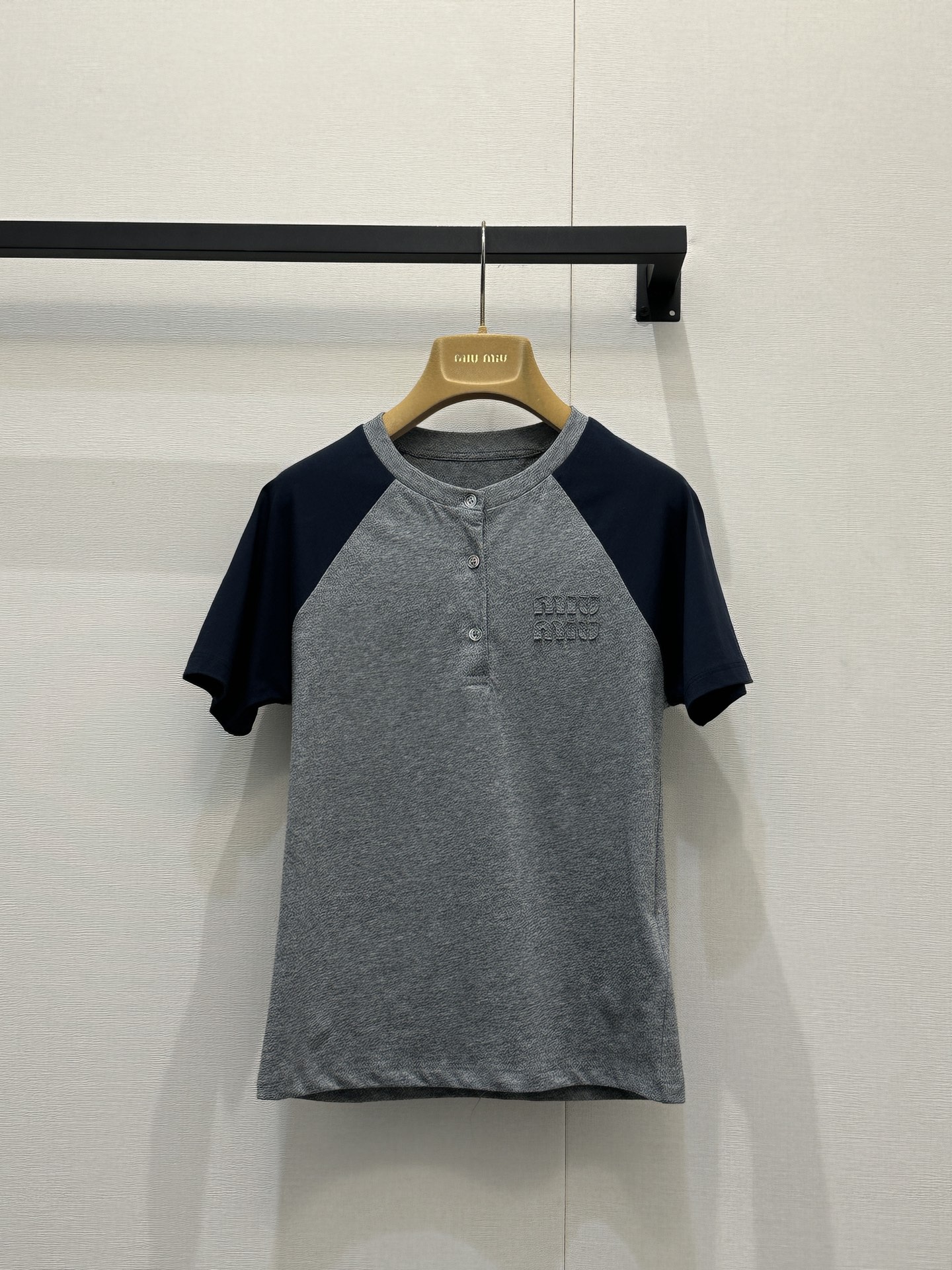 NO:734024,Miu M*u 26Ss early spring new style patch embroidered logo casual color block round neck short-sleeved T-shirt丨Exclusively developed!  Top quality production!  Based on retro college style, the classic raglan sleeve design is integrated into daily items. The contrasting gray and blue colors are refreshing and neat, with a relaxed and youthful atmosphere; the three-dimensional patch embroidered logo on the chest is a low-key finishing touch, and the delicate texture enhances the overall texture. The soft cotton blended fabric has both comfort and stiffness, and is tailored to fit the body.  The shape is not tight, and it can be worn with white wide-leg pants for a casual commuting style. Paired with a pleated skirt, it can create a sweet and cool girly look. It is a versatile style that can be worn in the wardrobe in early spring. Available in stock, S/M/L, large quantities, real shots, miumiu, skirts, T-shirts, tees, t-shirts,19860909Miu M*u 26Ss早春新款 贴布绣logo休闲拼色圆领短袖T恤丨独家开发！顶级高版出品！复古学院风为基调,将经典插肩袖设计融入日常单品.灰蓝撞色清爽利落,自带松弛的青春氛围感；胸前立体贴布绣Logo低调点睛,细腻的纹理感提升了整体质感.柔软的棉混纺面料兼具舒适度与挺括感,合身剪裁贴合身形却不紧绷,搭配白色阔腿裤是随性通勤风,配百褶裙又能演绎甜酷少女感,是早春衣橱里实穿度拉满的百搭款.现货发售S/M/L大货实拍,,miumiu,skirts,T-shirt,tees，t-shirt,,Women's clothing