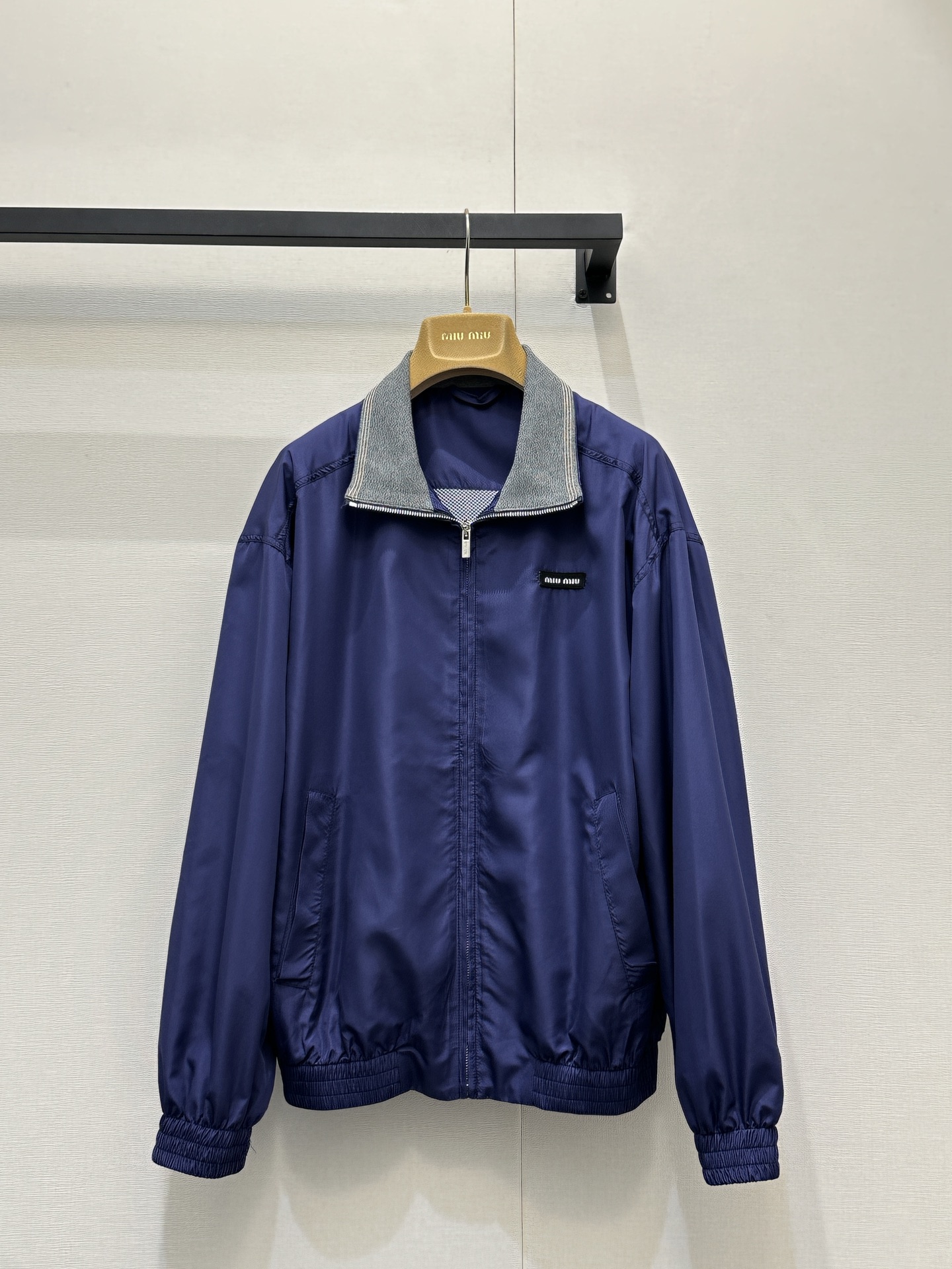 NO:735869,MiuM*u 26Ss new early spring zipper long-sleeved lapel jacket丨Exclusively developed!  Top quality production!  It is made of windproof nylon fabric with a matte texture, which has a soft drape and a delicate luster under different lights. The iconic contrasting lapel design breaks the calmness of the deep purple tone and echoes the iconic retro college atmosphere. The loose shoulder cut with elastic cuffs and hem can not only modify the body shape, but also adapt to the needs of layering.  .Pair it with a striped Polo shirt or a plaid dress, and you can easily create a relaxed yet sophisticated spring look. The mini logo on the chest discreetly points out your identity, making this jacket a versatile choice for daily outings and commuting. Available in stock, S/M/L, large quantities, real shots,, miumiu, skirts, jackets  & coats,jackets & coats,19860909MiuM*u 26Ss早春新款 拉链长袖翻领夹克外套丨独家开发！顶级高版出品！选用哑光质感的防风尼龙面料,自带柔和的垂坠感,在不同光线下泛着细腻光泽.标志性的撞色翻领设计,打破了深紫色调的沉稳,呼应了标志性的复古学院氛围.宽松落肩剪裁配合松紧袖口与下摆,既能修饰身形,又能适配叠穿需求.内搭条纹Polo衫或格纹连衣裙,都能轻松打造松弛又精致的春日造型.胸前的迷你徽标低调点明身份,让这件外套成为日常出街与通勤的百搭之选.现货发售S/M/L大货实拍,,miumiu,skirts,jackets & coats,jackets & coats,,Women's clothing