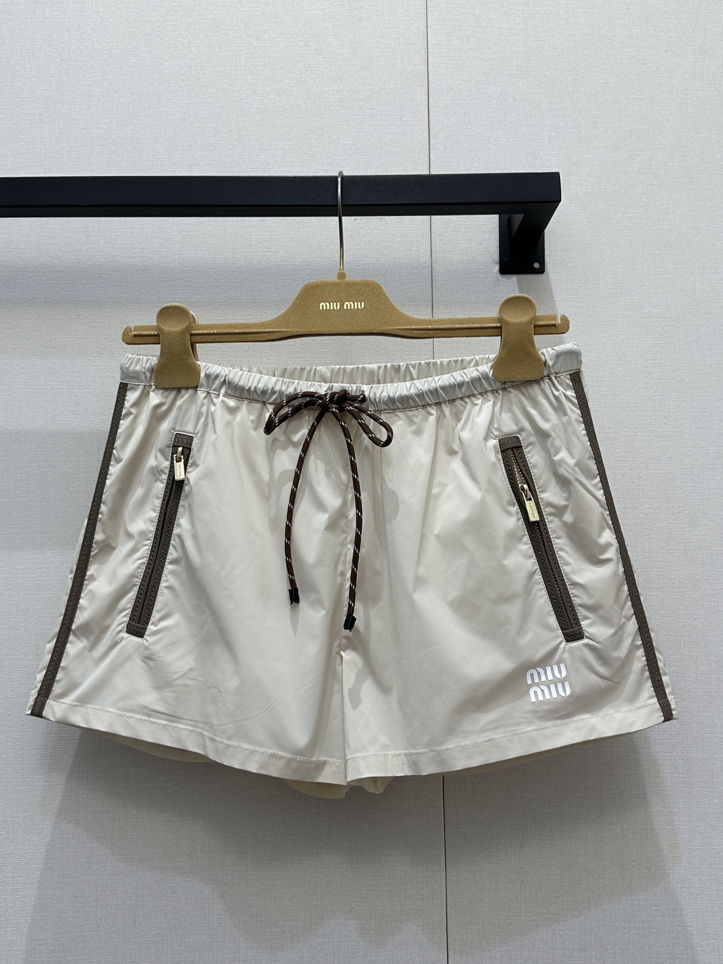 NO:737055,(Shorts) MiuMi* 2026 new spring and summer nylon zipper shorts, lightweight technical fabric, khaki color, super versatile, drawstring elastic waist + zipper pockets, practical and design, full of workwear style, suitable for daily street or outdoor use, brand embroidery on the trouser legs, exquisite details, comfortable and breathable loose fit, paired with the same series of sun protection jackets, you can easily get a high street fashion sense!  Size S M L large goods real shot,,miumiu,shorts,jackets & coats,19860909（短裤）MiuMi*2026春夏新款尼龙拉链短裤,轻薄科技面料,卡其色超百搭,抽绳松紧腰+拉链口袋,实用又有设计感,工装风满满,日常出街或户外都很适合,裤脚品牌刺绣,细节精致,宽松版型舒适透气,搭配同系列防晒外套,轻松get高街时髦感！码数S M L大货实拍,,miumiu,shorts,jackets & coats,,Women's clothing