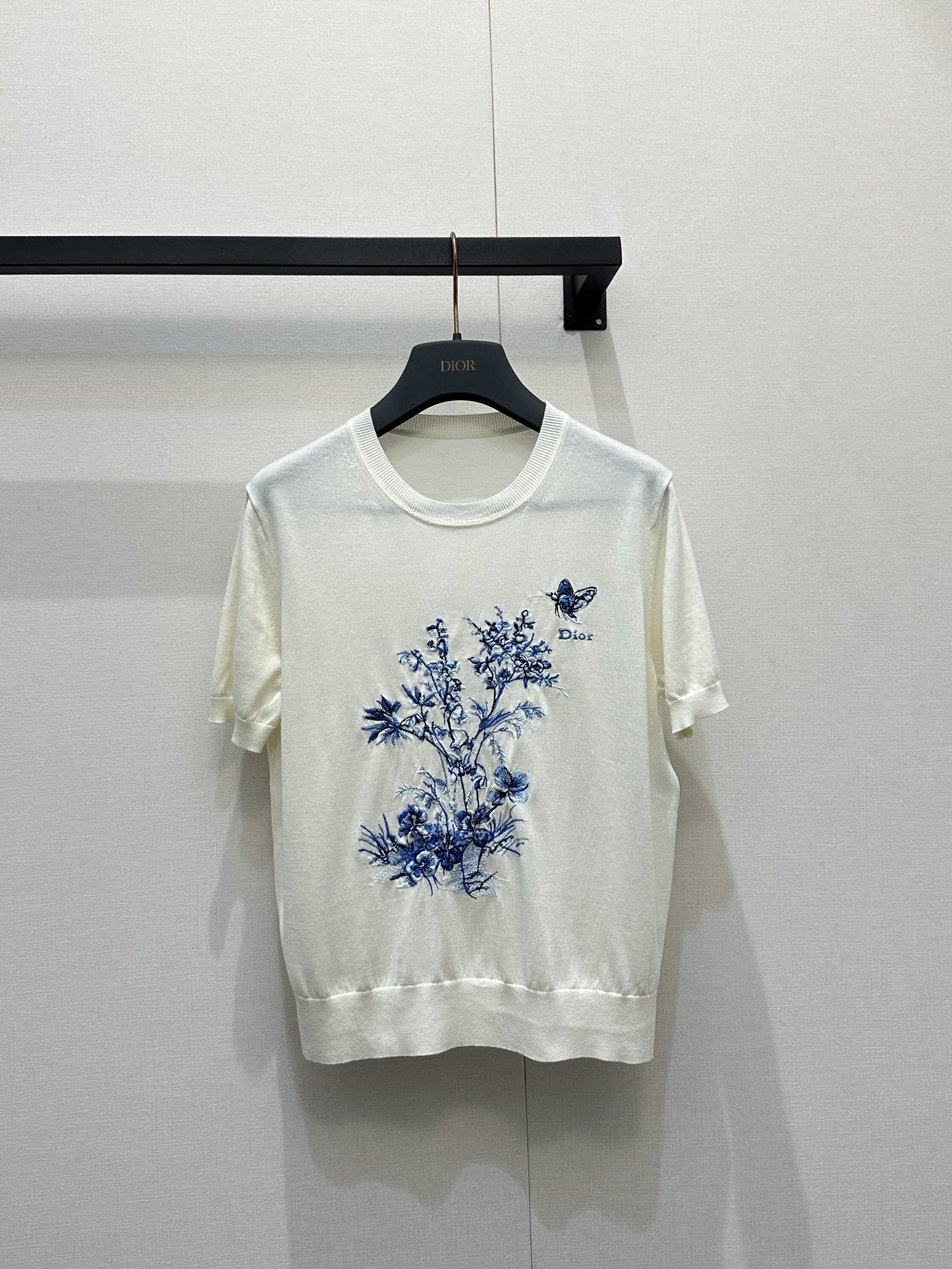 NO:795126,Dio*  2026 blue and white floral embroidered short-sleeved knitted sweater. This is a Chinese-style blue and white floral embroidered short-sleeved knitted sweater from the French luxury brand Dior. It is based on pure off-white and continues the brand's iconic elegant and refined design language. The body is made of delicate and light knitted fabric.  The front is embroidered with blue and white flower and butterfly patterns, and the 'Dior' letter logo is embellished on the side, which perfectly combines oriental aesthetics and French elegance. The round neck + short sleeves version is matched with ribbed edges, which is breathable and skin-friendly. It is the core item for creating a 'new Chinese socialite' spring and summer look.  Size S M L large goods real shot, dior, T-shirt,19860909Dio* 2026青花花卉刺绣短袖针织,这是来自法国奢侈品牌Dior的中式风青花花卉刺绣短袖针织衫,以纯净米白色为基底,延续品牌标志性的优雅精致设计语言,衣身采用细腻轻薄针织面料,正面绣有青花风格花卉与蝴蝶图案,旁侧点缀“Dior”字母徽标,将东方美学与法式优雅完美融合,圆领+短袖版型搭配罗纹收边,透气亲肤,是打造“新中式名媛”春夏造型的核心单品. 码数S M L大货实拍,,dior,T-shirt,,Women's clothing