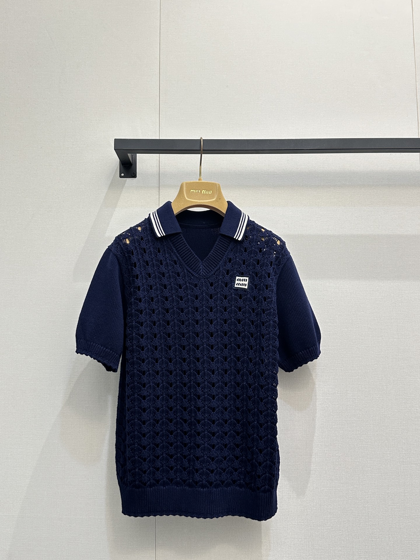NO:795637,Top 26 new Miu Miu dark blue hollow knitted suit. Dark blue hollow knitted Polo shirt [Wow R] is a classic Polo collar design. The dark blue tone is calm and high-end. The hollow knitting technology makes the whole dress breathable and light. It is not stuffy at all in summer ~ the small logo on the chest  The embroidery is low-key and exquisite, and the ribbed cuff design on the cuffs and hem makes the fit more crisp and not loose. The bottom is a hollow knitted skirt from the same series [Baji R]. The skirt is a loose fit, and the waist drawstring design can be freely adjusted for tightness and hollowness.  The texture echoes the top, and the overall feeling is super strong ~ the skirt is slightly spread out, and the walking is light and playful. It is the perfect combination of 'college style + little sexy'. SML real shots of large products,, miumiu, skirts,19860909上衣 26新款 Miu Miu深蓝镂空针织套装 深蓝镂空针织 Polo 衫[哇R]是经典的 Polo 领设计,深蓝色调沉稳又高级,镂空针织工艺让整件衣服透气又轻盈,夏天穿完全不闷热～胸前的小 Logo 刺绣低调精致,袖口和下摆的罗纹收口设计,让版型更挺括,不会松垮.下装是同系列镂空针织短裙[吧唧R]裙子是宽松版型,腰部抽绳设计可以自由调节松紧,镂空纹理和上衣呼应,整体感超强～裙摆微微散开,走起路来轻盈又俏皮,完全就是“学院风+小性感”的完美结合体.SML大货实拍,,miumiu,skirts,,Women's clothing