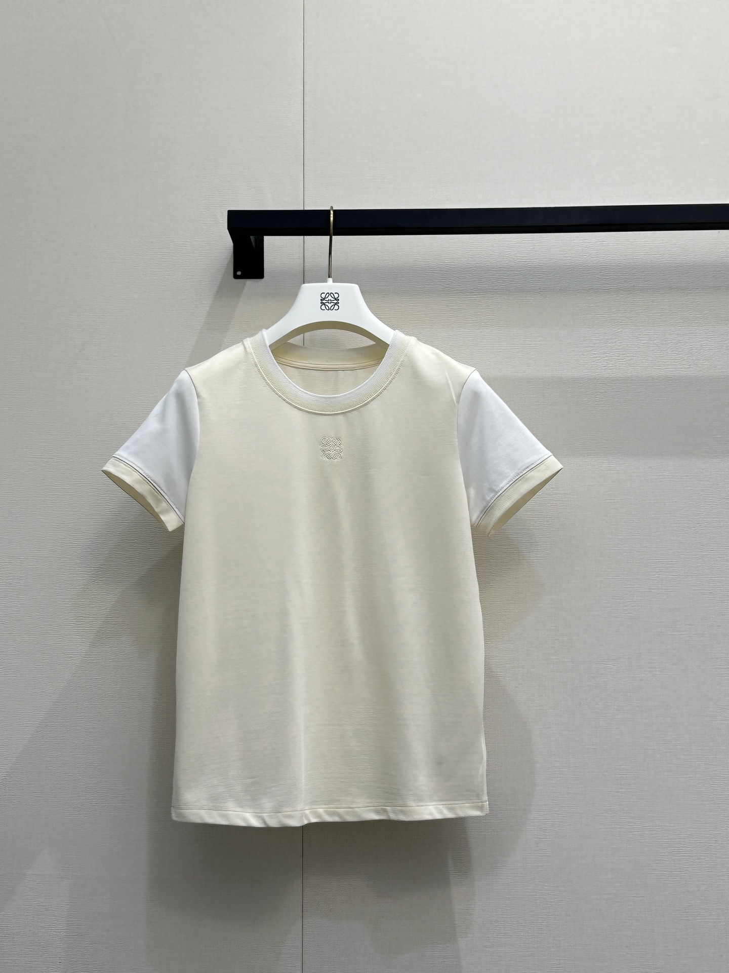 NO:795676,LOEWE26's new color-blocked short-sleeved T-shirt has a cream body with pure white raglan sleeves. The cuffs and collar are piping in the same color. It is visually clean, soft and layered. The same color embossed Anagram logo is used on the chest to low-key brand recognition and avoid an exaggerated logo. It is made of high-weight pure cotton or cotton blended fabrics, which is skin-friendly, breathable, crisp and slim.  The loose fit is suitable for a variety of body types. The raglan sleeve structure weakens the shoulder line and is friendly to slip-on and wide shoulders. The contrasting color splicing makes the basic model more design-like. The cream tone is gentle and white. It is a versatile light luxury item in spring and summer. It can be worn alone to create a simple and high-end feel. It can also be worn under a shirt or jacket, suitable for commuting, dating, traveling and other scenarios. Actual shot of large goods, loewe, jackets  & coats,shirts,T-shirt,tees,t-shirt,19860909LOEWE26新款拼色短袖T恤,奶油色衣身搭配纯白色插肩袖,袖口与领口同色系滚边设计,视觉上干净柔和又富有层次,胸前采用同色系压纹Anagram标识,低调彰显品牌辨识度,避免了夸张的logo感,选用高克重纯棉或棉混纺面料,亲肤透气且有挺括感,修身微宽松版型适配多种身材,插肩袖结构弱化肩线,对溜肩、宽肩都很友好,撞色拼接让基础款更具设计感,奶油色调温柔显白,是春夏百搭的轻奢单品,可单穿打造简约高级感,也可内搭在衬衫、外套里,适配通勤、约会、出游等多种场景.大货实拍,,loewe,jackets & coats,shirts,T-shirt,tees，t-shirt,,Women's clothing