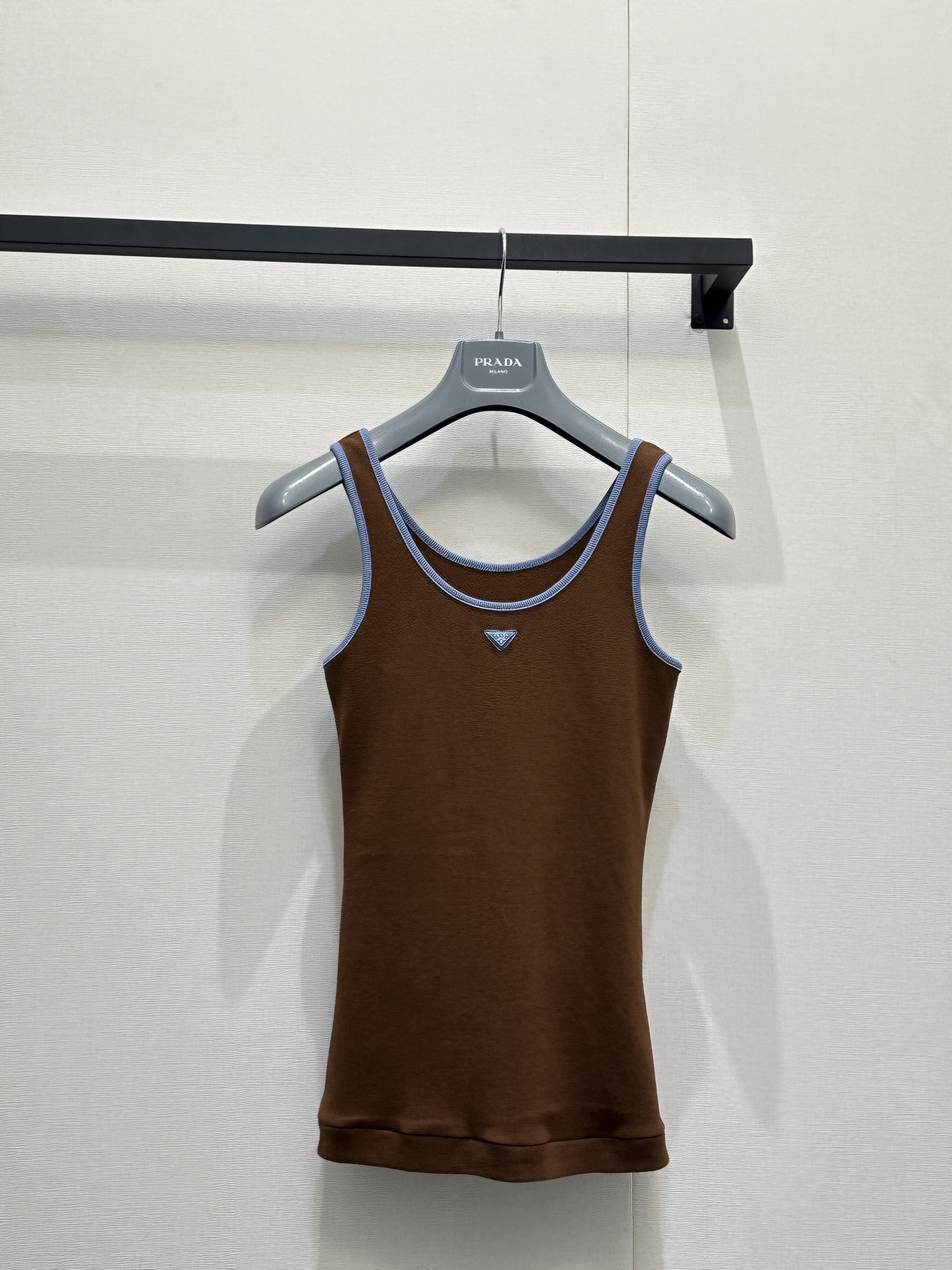 NO:796112,Prad*26 new caramel color contrast-edged vest, made of cotton, skin-friendly and breathable with delicate texture, light blue ribbed edge design on the neckline and shoulder straps, full of tenderness, inverted triangle logo embellishment on the chest, slim fit to fit the body shape, it is a retro American style item suitable for layering or wearing alone in spring and summer, with both warm texture and brand recognition. Size S M L, real shot of large goods,, prada,19860909Prad*26新款焦糖色撞色边背心,面料为棉,亲肤透气且带有细腻肌理,领口与肩带处的浅蓝罗纹撞边设计,温柔感拉满,胸前的倒三角徽标点缀细节,修身版型贴合身形,是适配春夏叠穿或单穿的复古美式单品,兼具暖调质感与品牌辨识度. 码数S M L大货实拍,,prada,,Women's clothing