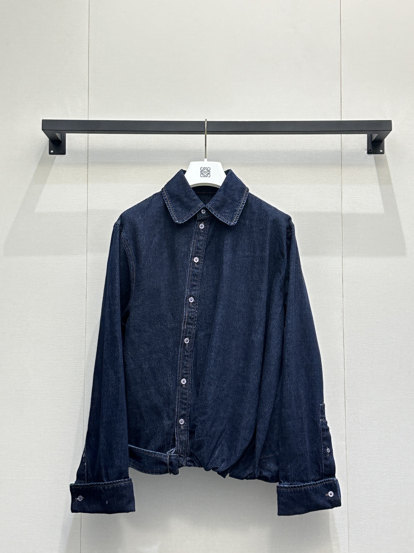 NO:801549,(jacket)  LOEW*26's new denim suit is based on heavy washed denim, perfectly integrating the brand's iconic minimalist aesthetics with a retro casual feel. The shirt adopts a classic lapel and diagonal side button design, breaking the stereotype of conventional shirts. The metal buckle at the waist is matched with an adjustable drawstring, which naturally forms a pleated waist effect, and is a neat short version.  The details of the shape and folded cuffs not only modify the body proportions, but also hide the exquisite ingenuity; the wide-leg jeans of the same series continue the brand's concept of comfortable and practical wear. The high-waist design is matched with front top-stitching to visually lengthen the leg line. The pockets on both sides are practical, and the buckle belt of the same fabric echoes the details of the shirt, making the whole look more complete.  Size S M L large goods real shot, loewe,jeans,jackets & coats,shirts,19860909（外套） LOEW*26新款牛仔套装以重磅水洗牛仔为基底,将品牌标志性的极简美学与复古休闲感完美融合.衬衫部分采用经典翻领与斜向侧排扣设计,打破常规衬衫的刻板感,腰部金属环扣搭配可调节抽绳,自然形成褶皱收腰效果,利落的短款版型与翻折袖口细节,既修饰身形比例,又暗藏精致巧思；同系列阔腿牛仔裤延续了品牌的舒适实穿理念,高腰设计搭配正面明线分割,视觉上拉长腿部线条,两侧插袋兼顾实用性,同面料环扣腰带则与衬衫细节形成呼应,让整套造型更具完整性. 码数S M L大货实拍,,loewe,jeans,jackets & coats,shirts,,Women's clothing