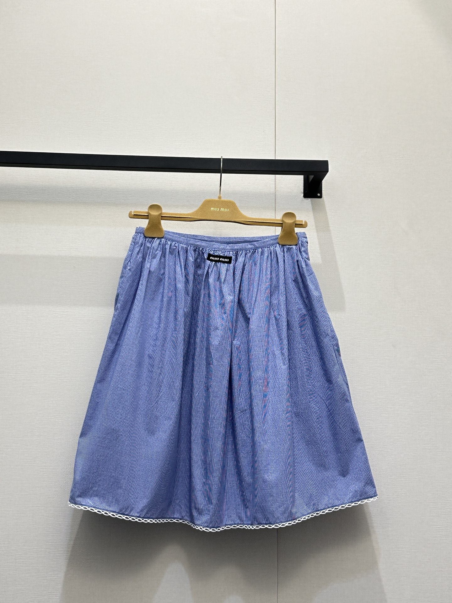 NO:802123,(Skirt) Miu Mi*26 new small plaid fresh girly style skirt is made of light blue fine plaid cotton blended fabric with white lace. The suspender tube top is designed with thin shoulder straps and side bow ties. It has a loose A-line shape. The hem and the edge of the neckline are decorated with white lace, and the hem is sewn with black Miu  Miu woven label; the short-sleeved lapel shirt of the same fabric is presented with a Peter Pan doll collar + single-row button placket. The cuffs and collar are also decorated with white lace, and a black Miu Miu woven label is sewn on the left chest. The overall texture is unified, which perfectly interprets the brand's iconic sweetness and retro atmosphere. Size S M L Large goods real shot,,miumiu,skirts,shirts,T-shirt,19860909（半身裙） Miu Mi*26新款小格子清新少女风半身裙 以浅蓝细格纹棉质混纺面料搭配白色蕾丝花边,吊带抹胸上衣采用细肩带+侧部蝴蝶结系带设计,宽松A字版型,下摆与领口边缘饰有白色蕾丝花边,下摆处缝有黑色Miu Miu织标；同面料短袖翻领衬衫则以彼得潘娃娃领+单排纽扣门襟呈现,袖口与领口同样饰有白色蕾丝花边,左胸位置缝有黑色Miu Miu织标,整体质感统一,完美诠释了品牌标志性的甜美元气与复古氛围. 码数S M L大货实拍,,miumiu,skirts,shirts,T-shirt,,Women's clothing