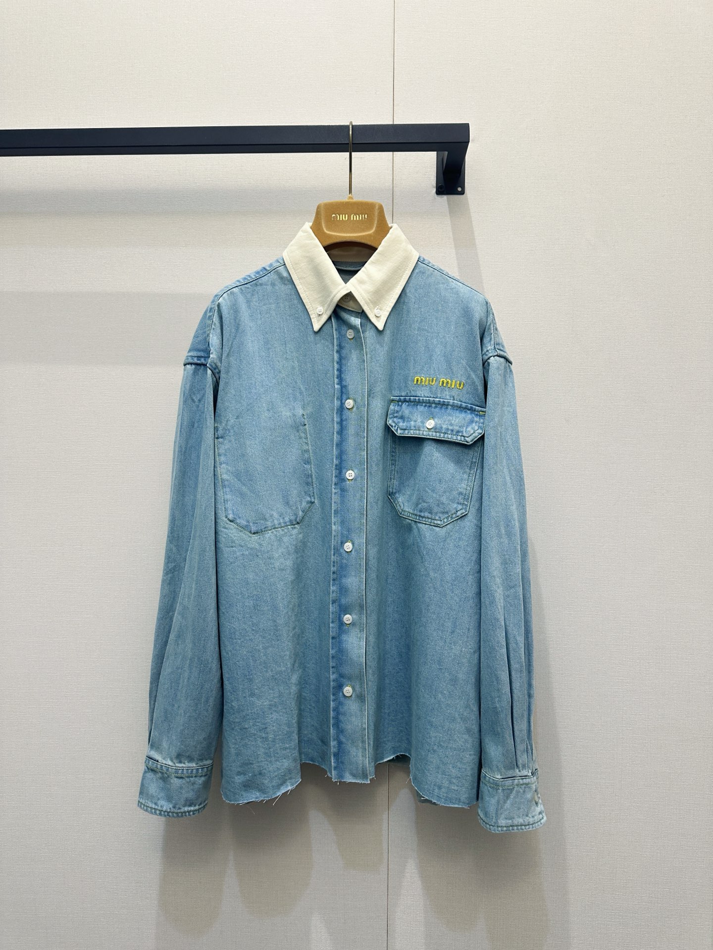 NO:806501,Miu Miu light blue contrast collar raw edge denim shirt, made of washed distressed denim fabric, soft light blue tone with retro texture, loose oversize drop shoulder version is very tolerant to the body shape, contrasting off-white corduroy collar and denim body in sharp contrast, double chest pockets with gold embroidery on the right side Miu Miu  Logo, the white buttons on the placket and cuffs are exquisitely detailed, and the irregular raw edges on the hem add a casual and uninhibited feel; it is a representative item of miu's retro casual style. It can be worn alone or layered as a jacket, suitable for spring, autumn, summer and winter. It can be paired with shorts, jeans, suits or vests to create a variety of styles such as sweet and cool, commuting, etc. The contrasting colors of light blue and off-white are fresh and soft, real shots of large quantities,,miumiu,versace,shorts,jeans,jackets &  coats,shirts,business suits,19860909Miu Miu浅蓝撞色领毛边牛仔衬衫,采用水洗做旧牛仔面料,柔和浅蓝调自带复古质感,宽松Oversize落肩版型对身形包容度极高,撞色米白灯芯绒领与牛仔衣身形成鲜明对比,胸前双口袋搭配右侧金色刺绣Miu Miu Logo,门襟与袖口的白色纽扣细节精致,下摆不规则毛边剪裁更添随性不羁感；它是miu系复古休闲风的代表单品,可单穿或作外套叠穿,适配春秋夏冬四季穿搭,能搭配短裤、牛仔裤、西装或马甲,打造甜酷、通勤等多种风格,浅蓝与米白的撞色清新柔和,大货实拍,,miumiu,versace,shorts,jeans,jackets & coats,shirts,business suit,,Women's clothing