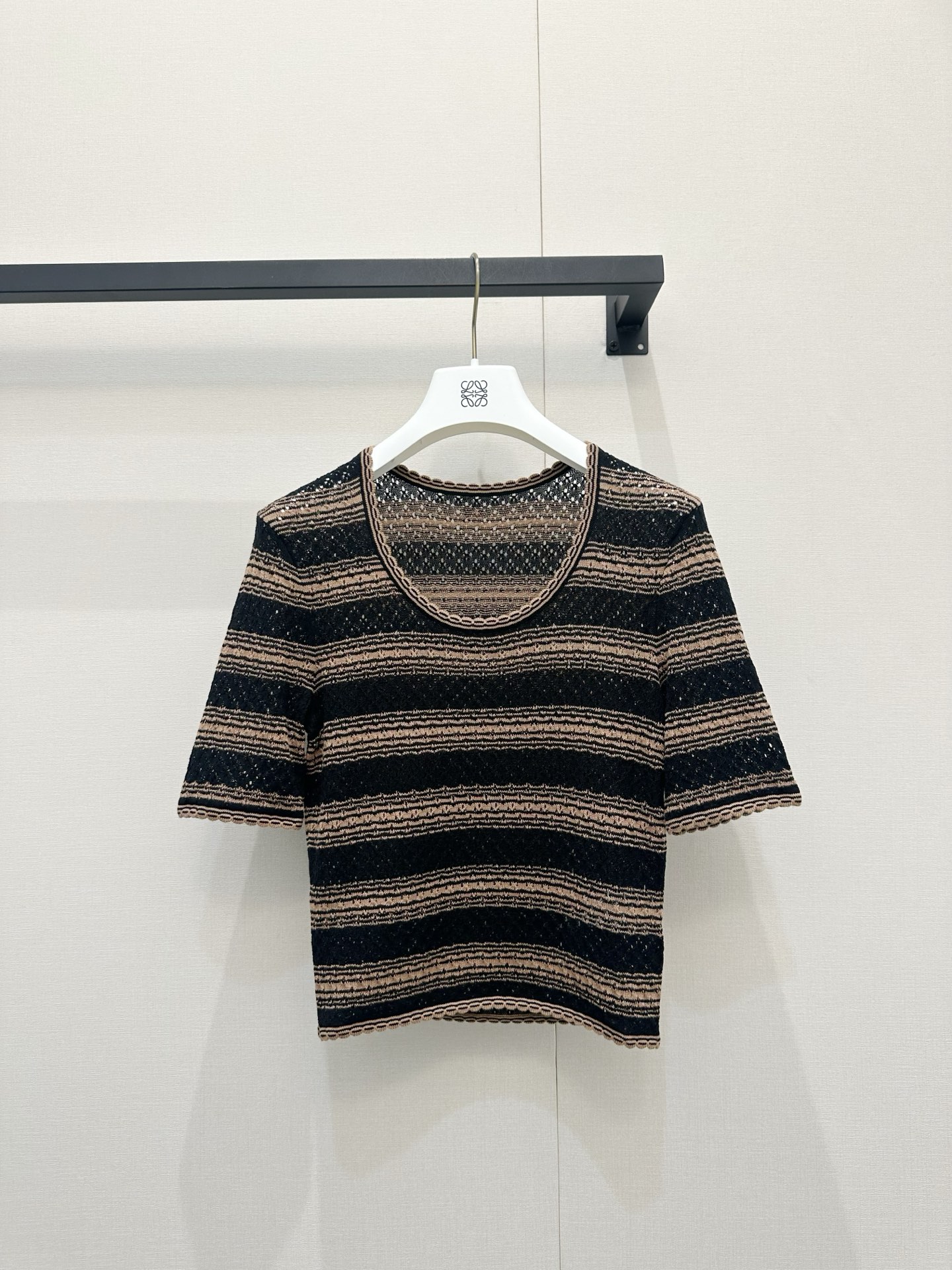 NO:839419,Loewe 2026 new black and brown pinstripe knitted short-sleeves, full of retro atmosphere!  The classic contrasting stripe design brings French laziness and intellectuality, and is visually very slimming. The exquisite wavy round neck and cuff details add a gentle breath to the whole without looking too rigid. The slim fit is just right, whether worn alone or layered as an inner layer, it can easily be worn to create a high-end sense of layering. The upper body has the look of a lady with temperament, and it is super fashionable to wear it casually with jeans or a skirt. It is really a treasure item that has become more and more timeless in the wardrobe!  Size SML,,loewe,skirts,jeans,T-shirt,19860909Loewe 2026新款 黑棕细条纹针织短袖,复古氛围感拉满！经典的撞色条纹设计,自带法式的慵懒与知性,视觉上非常显瘦.精致的波浪边圆领和袖口细节,让整体多了一丝温柔的呼吸感,不会显得过于刻板.修身的版型恰到好处,无论是单穿还是作为内搭叠穿,都能轻松穿出高级的层次感.上身就是气质大女主既视感,随便搭条牛仔裤或半裙都超级时髦,真的是衣柜里越穿越有味道的宝藏单品呀！尺码SML,,loewe,skirts,jeans,T-shirt,,Women's clothing