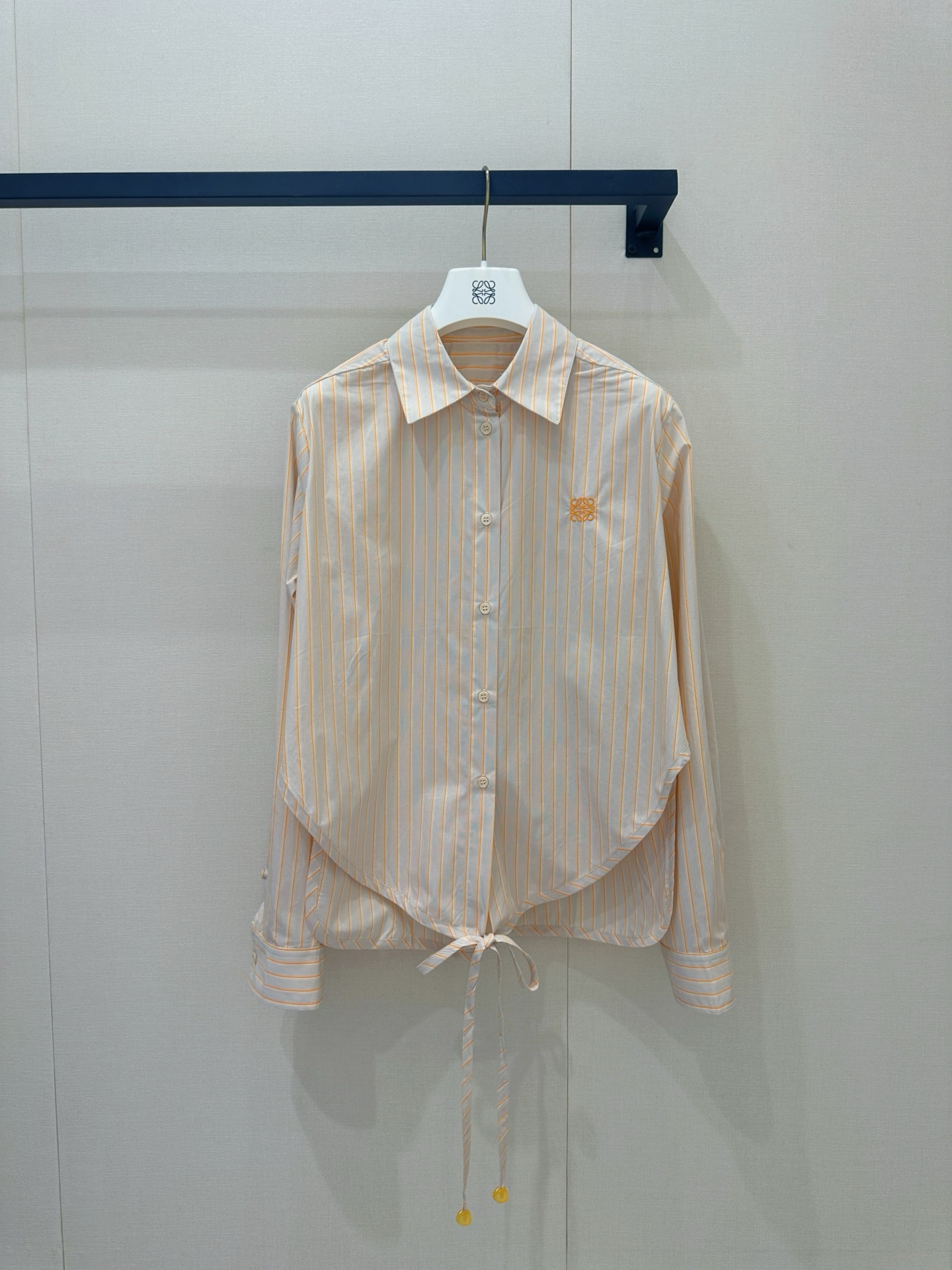 NO:868446,High version Loe**26 new spring and summer apricot striped waist shirt. Classic yellow and white vertical stripes bring a refreshing commuting feel. Asymmetrical tailoring + hem laces break the stereotyped shirt. The embroidery is low-key to highlight the brand style. The neat lapels + draped fabrics combine elegance and design. It is neat and slim when worn alone. It is easy to create a French high-end daily wear when layered. Ready for sale smL,, loewe, shirts,19860909高版本 Loe**26春夏新品 杏色条纹收腰衬衫 经典黄白竖条纹自带清爽通勤感,不对称剪裁+下摆系带,打破刻板衬衫 刺绣低调彰显品牌格调,利落翻领+垂坠面料,兼具优雅与设计感单穿利落显瘦,叠穿随性松弛,轻松打造法式高级的日常穿搭现货出售 smL,,loewe,shirts,,Women's clothing