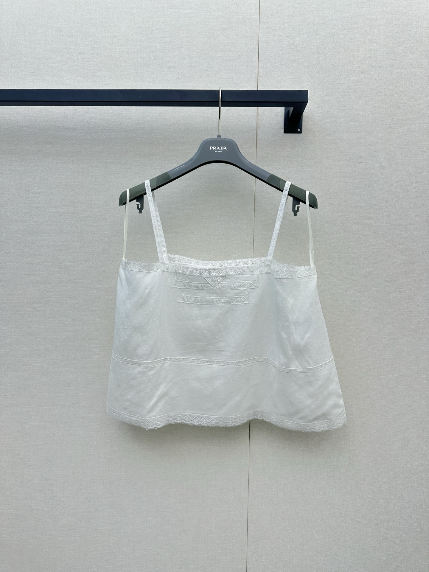 NO:878090,Prada  The new spring and summer 26 cotton and linen camisole brings you a refreshing and pleasant summer wearing experience with natural and breathable blended fabrics. The light texture seems to apply a layer of cool mint to the skin, which perfectly dissipates the sultry heat. In pure off-white color, the exquisite and delicate embroidery craftsmanship on the chest becomes the finishing touch. The complex texture is looming under the light and shadow, giving the item a low-key artistic quality and full of three-dimensional layers; supplemented by playfulness  The spaghetti strap design and wavy lace hem not only outline the soft shoulders and neck lines, but also reveal a lazy French style in the breeze. Whether worn as a layered suit jacket, or worn alone with high-waisted jeans or a pleated skirt, it can easily interpret a refreshing, refined, yet girly summer fashion attitude.,, prada, skirts, jeans, jackets  & coats, business suits,19860909Prada 26春夏新款棉质亚麻吊带背心,以天然透气的混纺面料为你带来清爽宜人的夏日穿着体验,轻盈的质地仿佛给肌肤敷上一层微凉的薄荷,完美驱散闷热；纯净的米白色调下,胸前精致细腻的刺绣工艺成为点睛之笔,繁复的纹理在光影下若隐若现,赋予单品低调的艺术质感与满满的立体层次；辅以俏皮的细肩带设计与波浪形的蕾丝花边下摆,不仅勾勒出柔美的肩颈线条,更在微风中透出一丝慵懒的法式风情,无论是作为内搭叠穿西装外套,还是单穿搭配高腰牛仔裤或百褶裙,都能轻松演绎出清爽脱俗、高级又不失少女感的夏日时尚态度.,,prada,skirts,jeans,jackets & coats,business suit,,Women's clothing