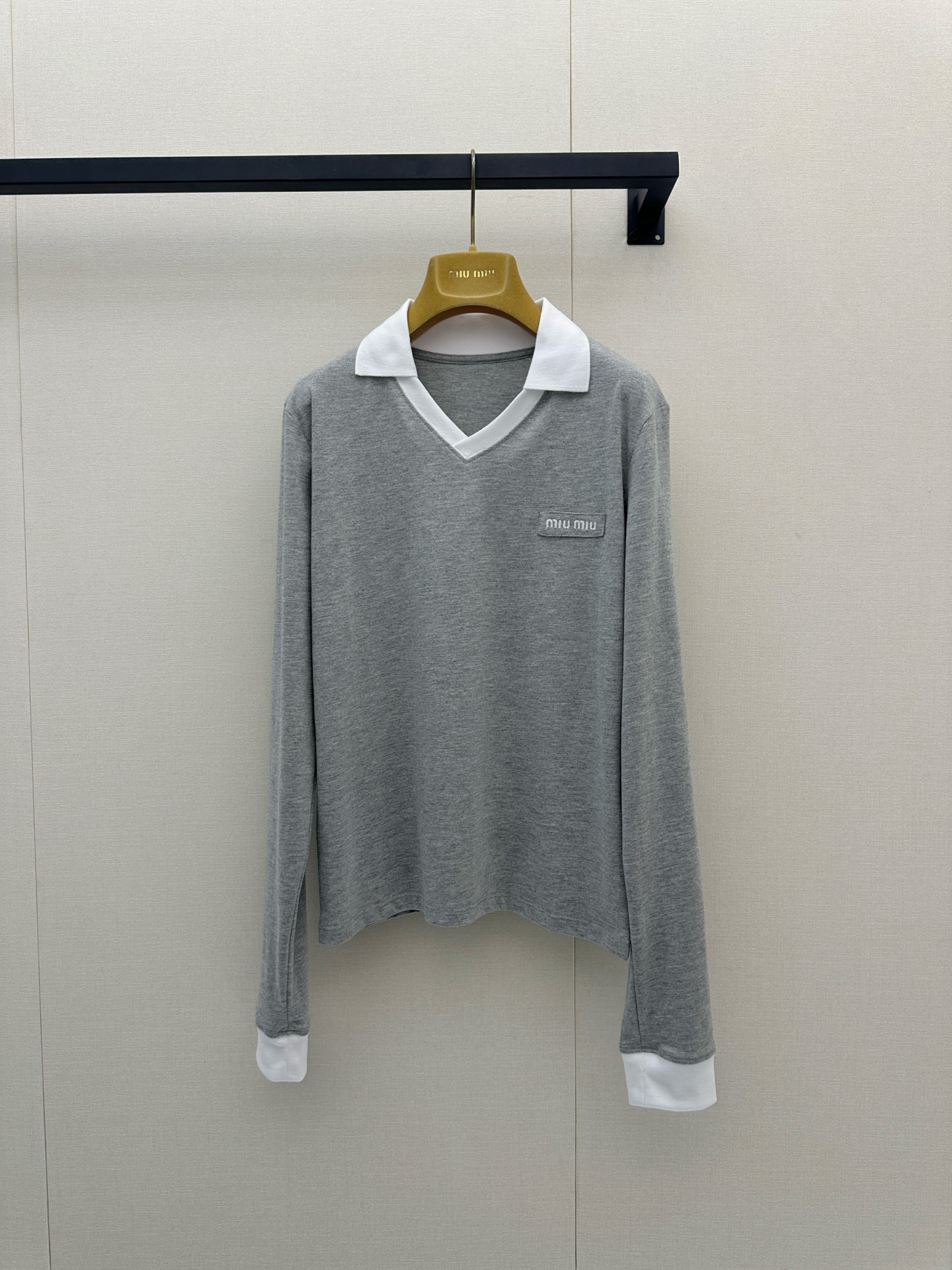 NO:892974,26 spring and summer new products  miu** gray contrasting white POLO collar long sleeves, replicating the light and luxurious tone of college style. Contrast color lapels and cuffs outline the layering, V-shaped neckline modifies the neck line, and exquisite small logo on the chest hides the brand texture. Soft, skin-friendly blended fabric, slightly cut at the hem  Tailored to optimize body proportions, the neat short style is suitable for high-waisted bottoms. It is relaxed and age-reducing and has a well-behaved lady atmosphere. It can be matched with your daily commuting and leisure travels. It is easy to choose a lazy and exquisite Korean style. Ready for sale smL,, miumiu,1986090926春夏新品 miu**灰撞白POLO领长袖,复刻学院风轻奢调性.撞色翻领与袖口勾勒层次,V型领口修饰脖颈线条,胸口精致小标暗藏品牌质感.软糯亲肤的混纺面料,下摆微收剪裁优化身形比例,利落短款适配高腰下装.松弛减龄又自带乖巧名媛氛围,日常通勤、休闲出游随心搭配,轻松拿捏慵懒精致的韩系穿搭.现货出售smL,,miumiu,,Women's clothing