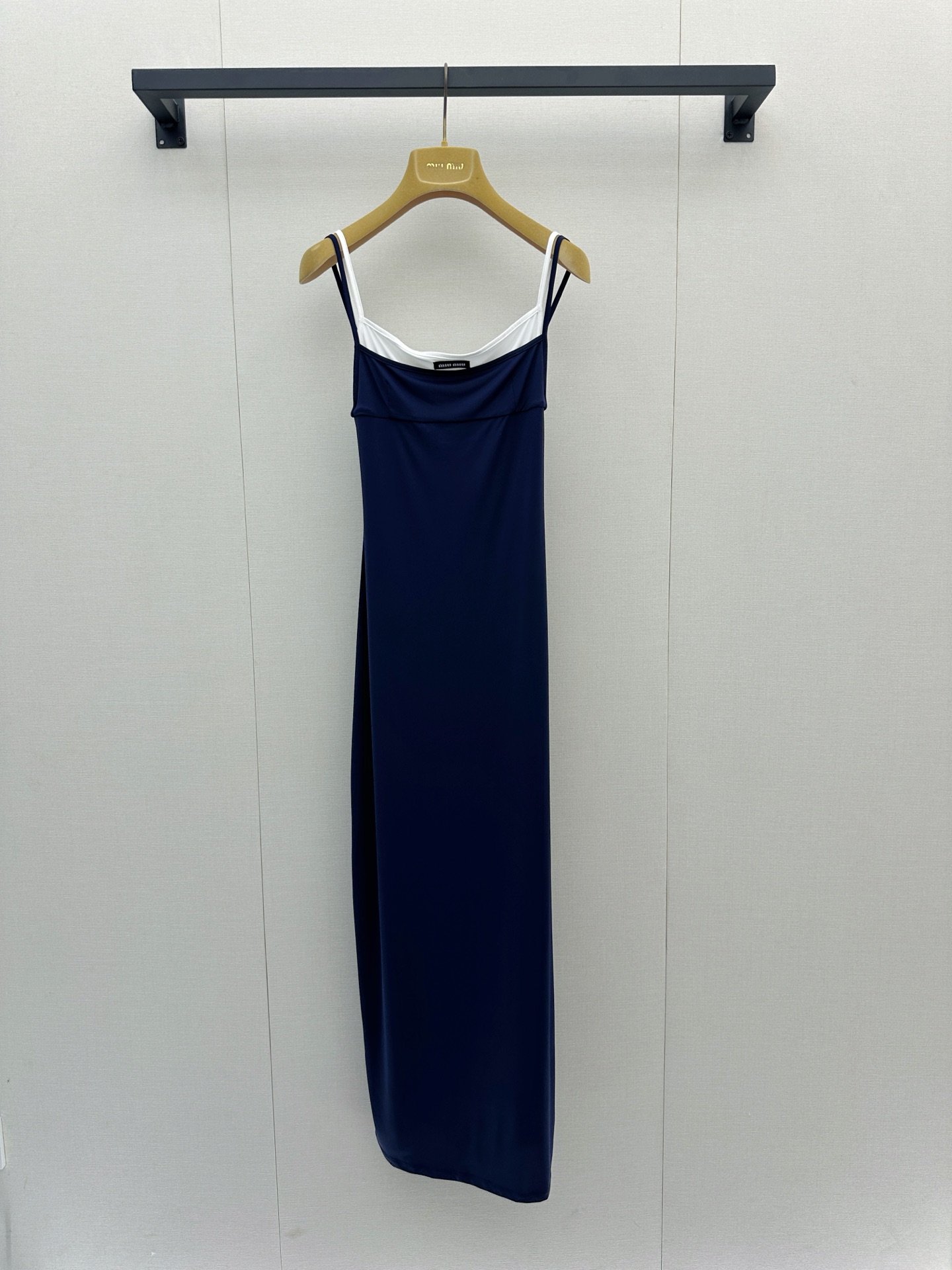 NO:908309,Miu Miu  26's new fake two-piece swing collar suspender long dress, with deep navy as the main tone, and an off-white inner layer, creating a very layered visual effect. This dress is made of a blended fabric of 73 recycled nylon and 27 spandex, which not only fits the body shape and is elastic, but also reflects the brand's positive response to sustainable fashion. The spaghetti strap design is simple and exquisite, and the slightly swinging neckline cleverly modifies the neck line, revealing a trace of laziness and sexiness;  The straight skirt is cut and draped smoothly, which can well outline the body curve, making it look tall and elegant. Whether worn alone to show French romantic style, or paired with a suit jacket to cope with the temperature difference between morning and evening, it is a wardrobe essential that has both design and practicality, allowing you to easily exude charming Miu style charm while walking in the city. Size SML is in stock, miumiu, skirts, jackets  & coats, business suits,19860909Miu Miu 26新款假两件荡领吊带长裙,以深邃的藏青色为主调,搭配内层的米白色打底,营造出极具层次感的视觉效果.这款连衣裙采用了73再生锦纶与27氨纶的混纺面料,不仅贴合身形、富有弹性,更体现了品牌对可持续时尚的积极响应.细肩带设计简约精致,微荡的领口巧妙修饰颈部线条,流露一丝慵懒与性感；修身的直筒长裙剪裁流畅垂坠,能够很好地勾勒出身材曲线,既显高挑又优雅大方.无论是单穿展现法式浪漫风情,还是搭配西装外套应对早晚温差,它都是一件兼具设计感与实穿性的衣橱必备单品,让你在都市漫步中轻松散发迷人的Miu系魅力.尺码SML大货实拍,,miumiu,skirts,jackets & coats,business suit,,Women's clothing