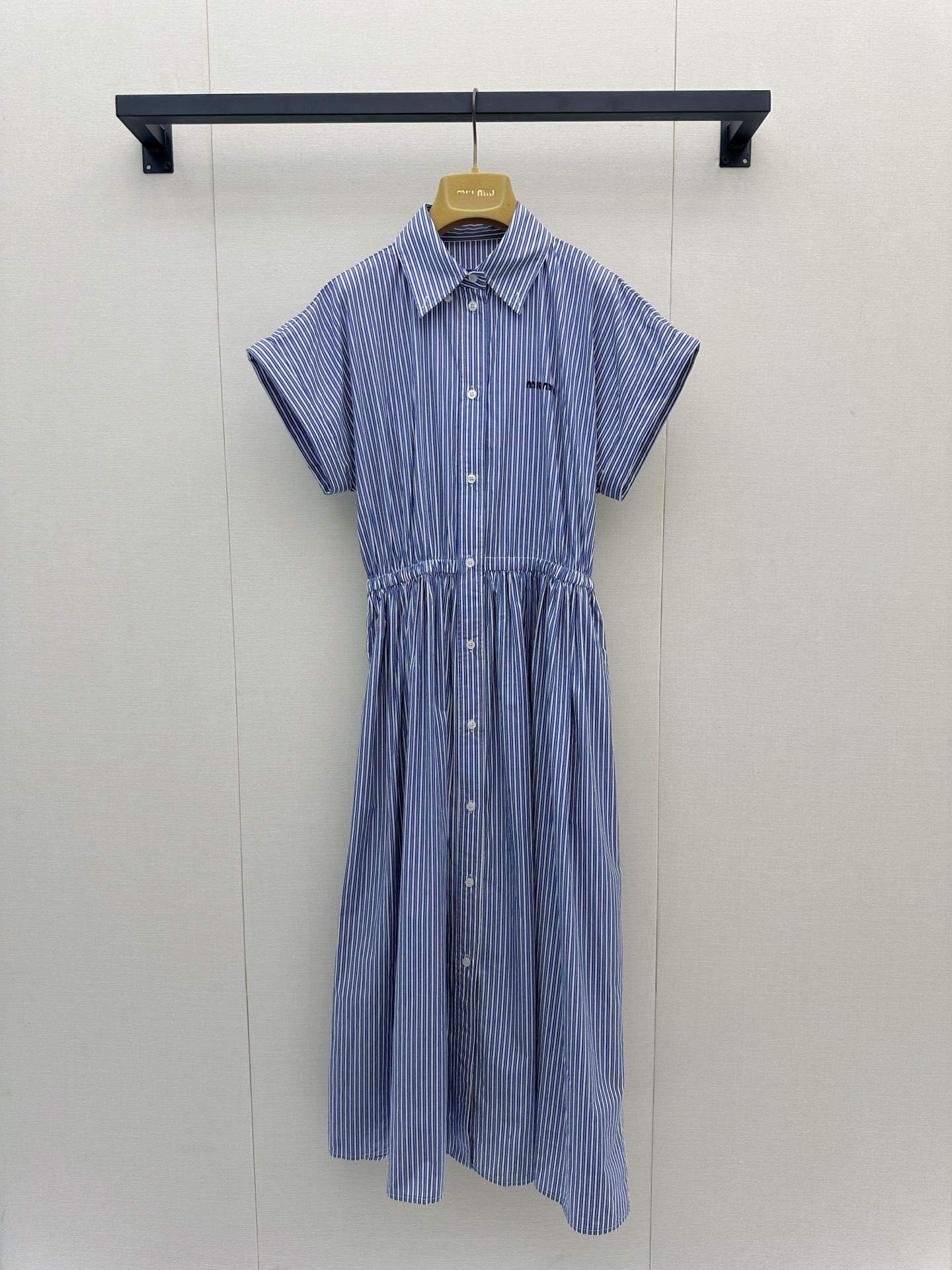 NO:909671,Miumiu 26 new spring and summer short-sleeved dress. The blue and white striped weave makes it relaxed and everyday. The sleeveless cut reveals the sharp shoulder line. The front buttons and waist pleats outline the soft waistline. The drape skirt hides all body concerns. It is light and breathable, suitable for commuting and weekends. It has a refreshing atmosphere and is a summer narrative that will never fade in the wardrobe. Spot sml big goods real shot,, miumiu, skirts, T-shirt,19860909Miumiu 26春夏新品短袖连衣裙 蓝白条纹织就松弛日常,无袖剪裁展露利落肩线,前排纽扣与收腰褶裥勾勒柔和腰线,垂坠裙摆藏起所有身材顾虑.轻透气场适配通勤与周末,自带清爽氛围感,是衣橱里永不褪色的夏日叙事.现货smL 大货实拍,,miumiu,skirts,T-shirt,,Women's clothing