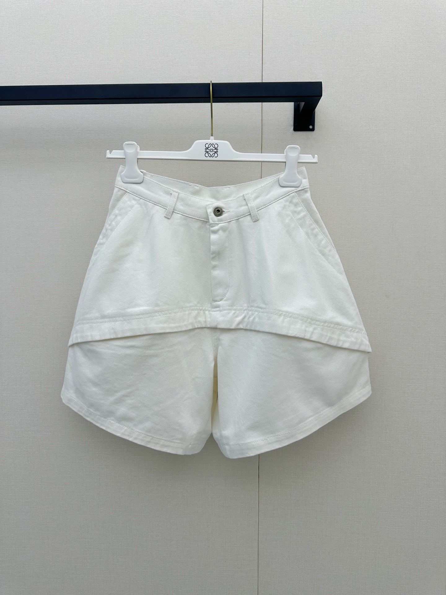 NO:948568,Loewe  The new spring and summer 26 white shorts awaken the freshness and vitality of summer with the classic and versatile white color. They are carefully made of light and breathable fabrics. The upper body feels cool and comfortable, perfect for resisting the scorching sun. The tailoring is neat and generous, and the unique asymmetrical splicing line design on the front not only enriches the visual hierarchy, but also shows the extraordinary design ingenuity and architectural beauty in the details, easily breaking the monotony. It is paired with a simple waistband and silver buttons.  Embellished, the overall style is casual yet high-end. Whether it is paired with a loose shirt of the same color to create a lazy holiday style, or paired with a simple white T-shirt and sneakers to create a casual street style, it can be used with ease. It is an indispensable fashion item in your summer wardrobe to relieve the heat. SML real shots, loewe, sneakers, shorts, shirts, tees, t-shirt,19860909Loewe 26春夏新款白色短裤,以经典百搭的白系唤醒夏日的清爽与活力,甄选轻薄透气的面料精心打造,上身触感凉爽舒适,完美对抗炎炎烈日；剪裁利落大方,前片别致的不对称拼接线条设计,不仅丰富了视觉层次,更在细节处彰显出不凡的设计巧思与建筑美感,轻松打破单调；搭配简约的腰头与银色纽扣点缀,整体风格休闲又不失高级质感,无论是搭配同色系宽松衬衫打造慵懒度假风,还是配以简约白T恤与运动鞋演绎随性街头感,都能游刃有余,是您夏日衣橱中不可或缺的解暑时髦单品.SML大货实拍,,loewe,sneakers,shorts,shirts,tees，t-shirt,,Women's clothing