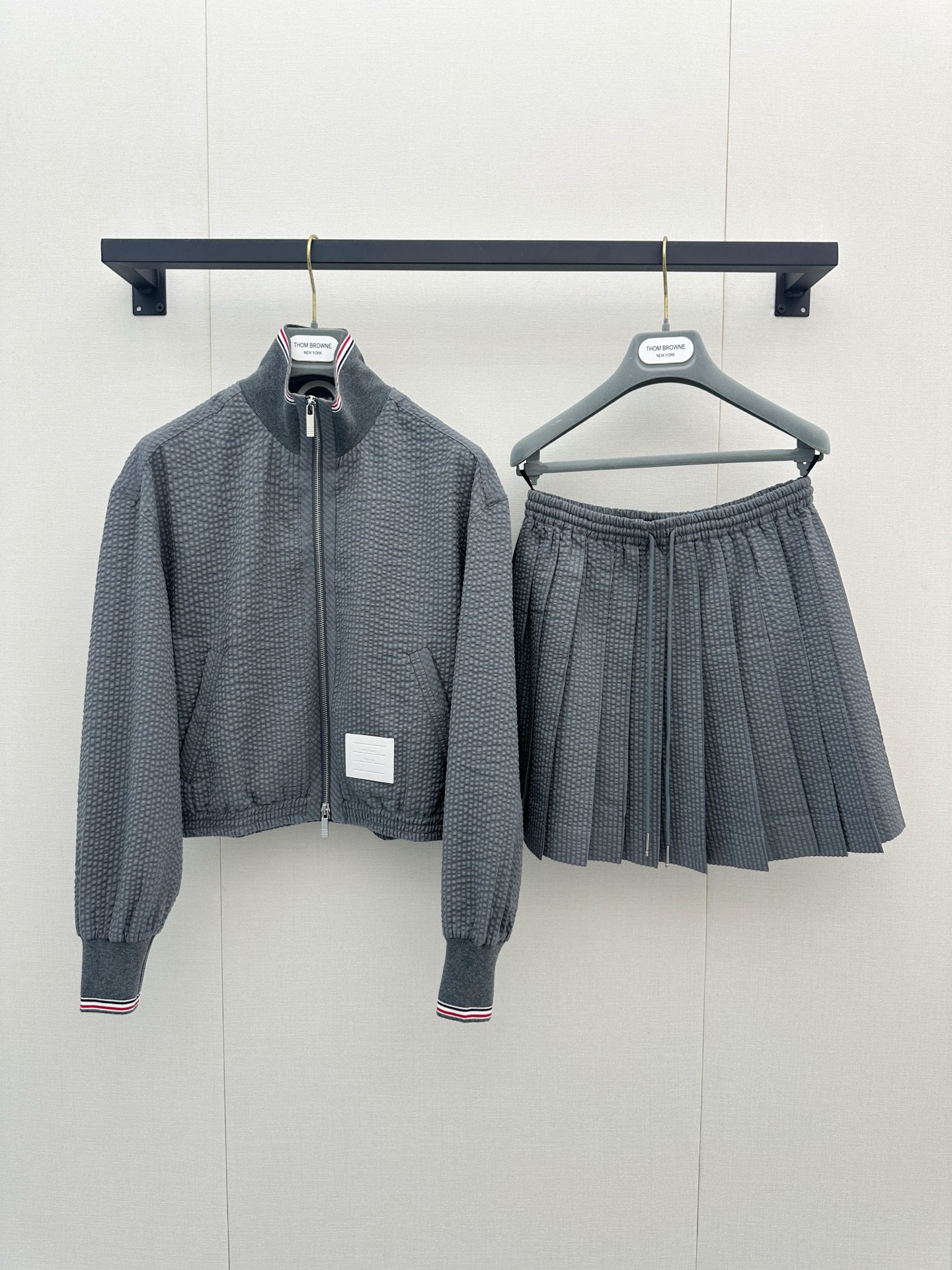 NO:950191,Thom Browne’s new spring/summer 26 seersucker suit is also amazing!  High-grade gray seersucker fabric has its own three-dimensional texture, which is more textured than ordinary fabrics and is not picky at all!  The short jacket + pleated skirt perfectly raises the waistline, covers the flesh and shows the length of the legs, and perfectly captures the sophistication of American preppy style. Whether it is commuting or vacationing, this set is directly welded to the body. I tried it and it feels really good. The upper body is very comfortable. It is light and breathable. There is no sense of restraint. The lower right mark is leather. The details are in place. It is versatile and easy to wear. Actual photos of SML's large products, skirts, jackets & coats,19860909Thom Browne 26年春夏新款泡泡纱套装也太绝了！高级灰泡泡纱面料,自带立体肌理感,比普通面料更显质感,完全不挑人！ 短款夹克+百褶半裙,完美拉高腰线,遮肉又显腿长,把美式学院风的精致感拿捏得死死的. 无论是通勤还是度假,这一套直接焊在身上 试了一下感觉真的不错 上身舒适度很高 轻薄透气 没有束缚感 活动自如 右下标是皮质的 细节到位 百搭好穿 SML大货实拍,,skirts,jackets & coats,,Women's clothing