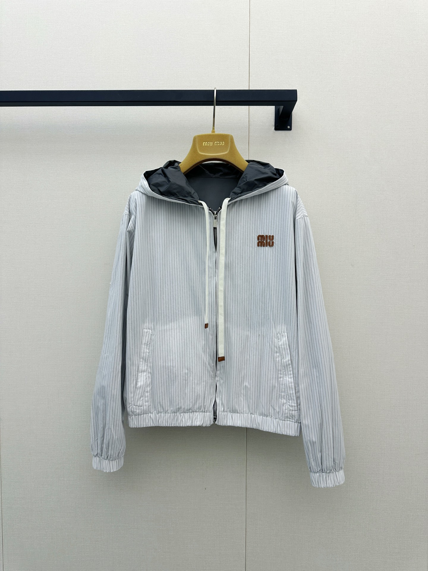 NO:951690,Miu Miu 26's new reversible hooded jacket really takes the practical aesthetics of 'one outfit and two wears' to the extreme, easily achieving a sweet, cool girlish look and a casual and relaxed feel!  One side is made of high-grade dark gray lightweight nylon fabric with a slightly wrinkled texture, paired with contrasting off-white drawstrings and eye-catching Hermès orange 'MIU'  MIU' letter embroidery brings a cool street style; flip to the other side and it is a fresh pinstripe texture fabric, which is gentle and has a retro college atmosphere. The front and back sides can be switched as the facade, and you no longer have to worry about matching when going out ~ The hem and cuffs of the clothes are designed with comfortable elastic cuffs, which not only can be used very well  It is extremely tolerant of all body types, and can also cleverly optimize body proportions. It is windproof and slimming. In early spring or on a cool summer night, you can easily put it on and go out. Whether it is paired with a slim-fitting hot girl outfit or casual wide-leg pants, it will look great. One piece of clothing unlocks N possible outfits. It is definitely a treasure item that is highly utilized in the wardrobe!  Size SML Reversible,,hermes,miumiu,jackets & coats,hats,19860909Miu Miu 26新款双面穿连帽夹克真的是把“一衣两穿”的实用美学玩到了极致,轻松拿捏甜酷少女感与随性松弛感！ 一面是高级深灰调的轻盈尼龙面料,带有微微的褶皱肌理感,搭配撞色米白色抽绳与亮眼的爱马仕橙“MIU MIU”字母刺绣,街头酷飒风拉满；翻转到另一面则是清新的细条纹肌理面料,温柔又带点复古学院气息,正反两面都能作为门面随心切换,出门再也不用纠结搭配啦～衣服下摆和袖口采用了舒适的松紧收口设计,不仅能很好地包容各种身材,还能巧妙优化身材比例,防风又显瘦.早春或者微凉的夏夜,随便套上它就能轻松出街,无论是搭配修身辣妹装还是休闲阔腿裤都超级出片,一件衣服解锁N种穿搭可能,绝对是衣橱里利用率超高的宝藏单品呀！尺码SML双面穿,,hermes,miumiu,jackets & coats,hats,,Women's clothing