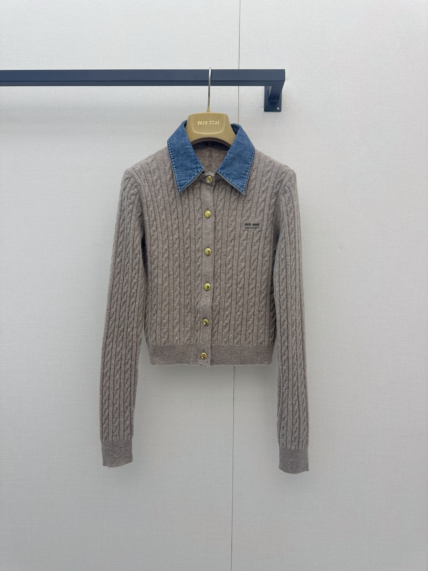 NO:953203,Miu Miu 26 new early spring denim collar knitted cardigan has 'the playfulness of a college girl' and 'the elegance of a wealthy socialite' woven into every inch of the texture~ The gentle oatmeal beige knitted texture is delicate and soft, and the contrasting retro denim blue lapel instantly brightens the vision, like cutting a corner of a clear spring sky and draping it over the shoulders; the classic twist twist texture has its own handmade warmth, and the golden old buttons sparkle slightly in the light. Miu has a small left chest  The Miu embroidery label is a low-key statement of identity; the luxurious blend of 70% wool and 30% cashmere is selected, which is as light and warm as a cloud, without any pricking feeling. The short slim fit is precisely stuck at the thinnest part of the waistline. Paired with a high-waisted pleated skirt, it is a 'library sweetheart'; paired with bootcut jeans, it instantly transforms into a 'street sweet and cool girl'; from a cafe where you are rushing to write a paper to a gallery  At the opening reception, one piece can change all the 'effortlessly fashionable' scenes. It is the atmospheric artifact in the closet that 'is obviously very expensive, but it feels like you have stolen your boyfriend's jacket'. When you put it on, even the wind can't help but slow down for you. Real photos of large items in size SML, miumiu, skirts, jeans, jackets  & coats,19860909Miu Miu 26早春新款牛仔领针织开衫,把“学院少女的俏皮”和“千金名媛的贵气”织进了每一寸肌理里～温柔燕麦米色针织肌理细腻软糯,撞色复古丹宁蓝翻领瞬间点亮视觉,像把春日晴空裁了一角披在肩上；经典麻花绞花纹理自带手工温度,金色做旧纽扣在光下微微闪烁,左胸小巧的Miu Miu刺绣标低调宣誓着身份；甄选70羊毛与30羊绒的奢华混纺,贴肤如云朵般轻盈暖柔,毫无扎刺感,短款修身版型精准卡在腰线最细处,搭配高腰百褶裙是“图书馆甜心”,配微喇牛仔裤又秒变“街头甜酷辣妹”；从赶论文的咖啡馆到画廊开幕酒会,一件就能切换所有“毫不费力的时髦”场景,是衣橱里那件“明明很贵,却像偷穿了男朋友外套”的氛围感神器,穿上它,连风都忍不住为你放慢脚步.尺码SML大货实拍,,miumiu,skirts,jeans,jackets & coats,,Women's clothing